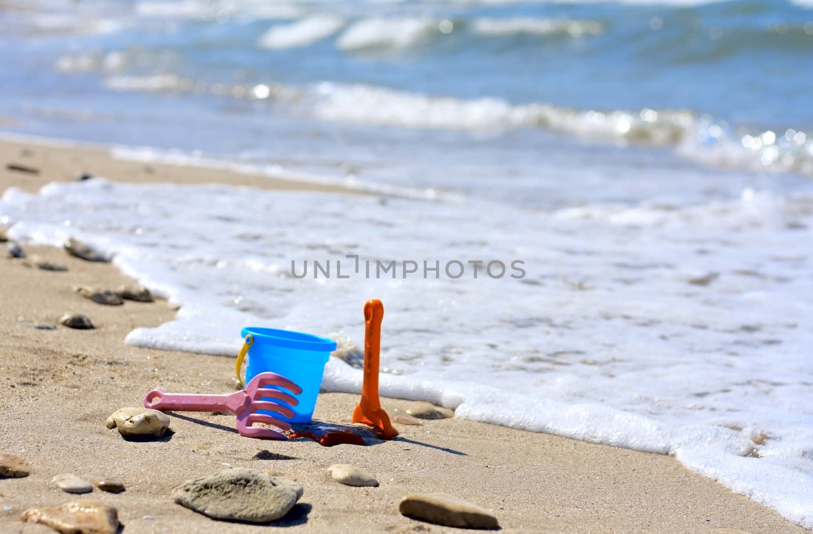 Plastic bucket on the beach near the sea