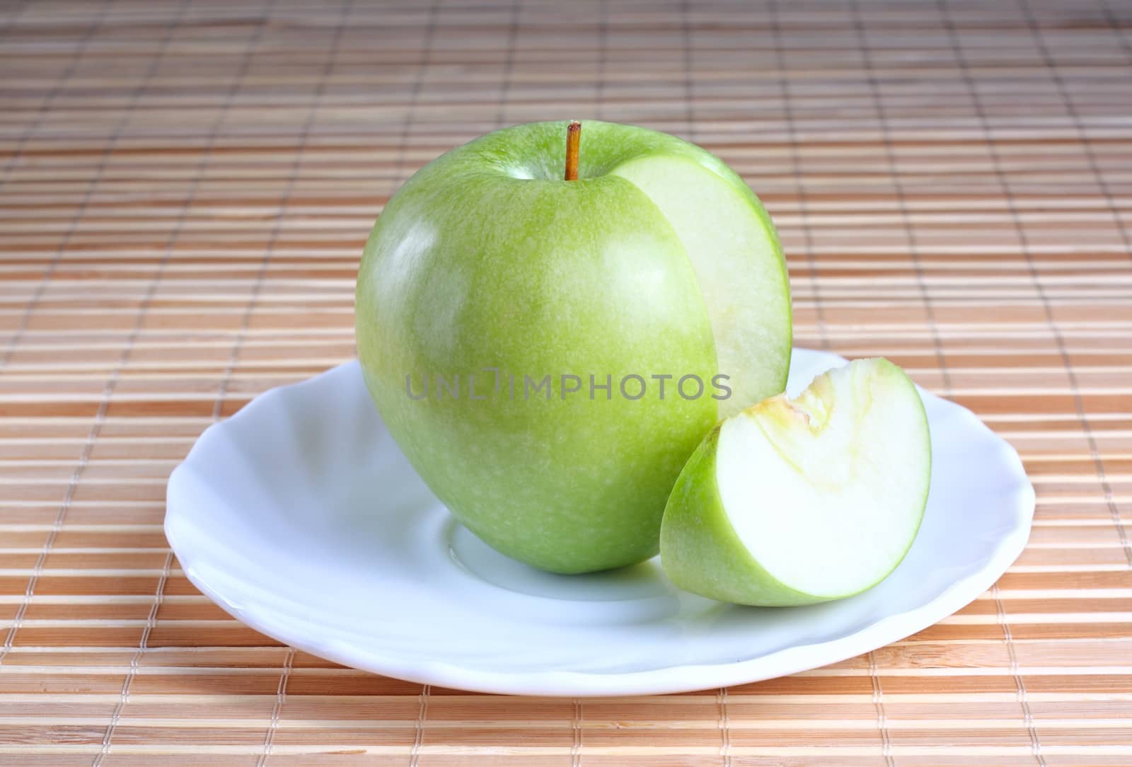 Apple with a piece on the plate at the textured background