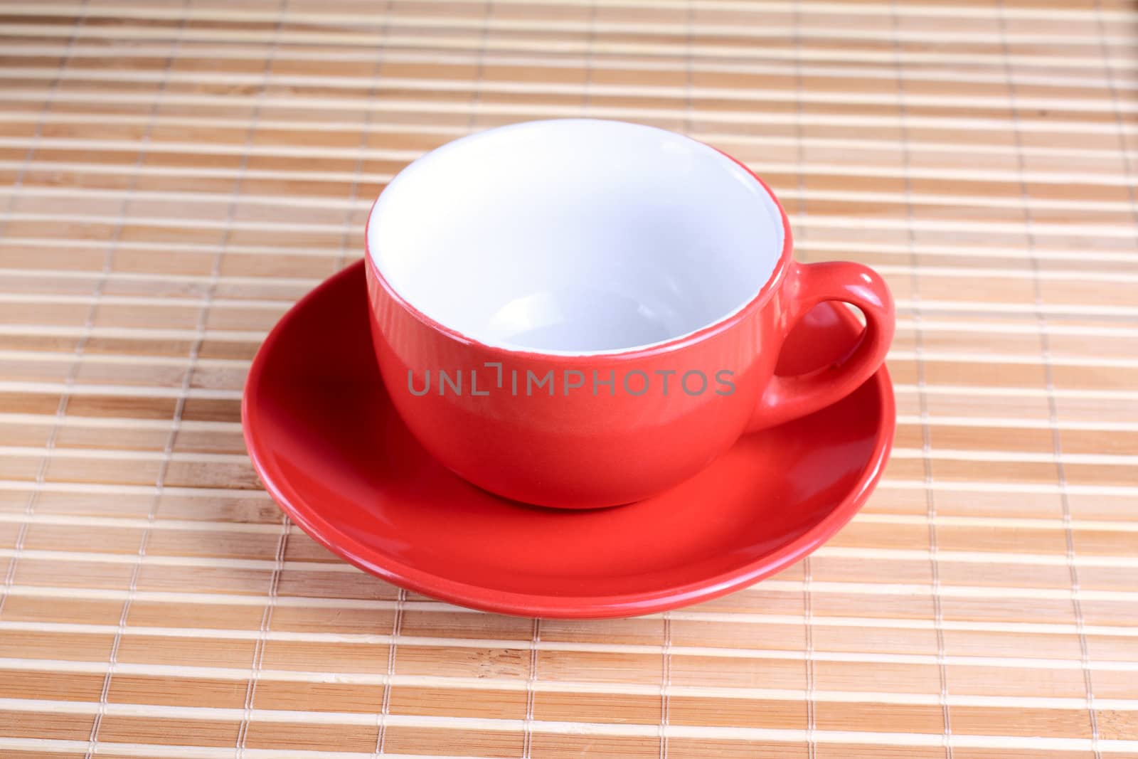 Empty red cup on the plate at the textured background