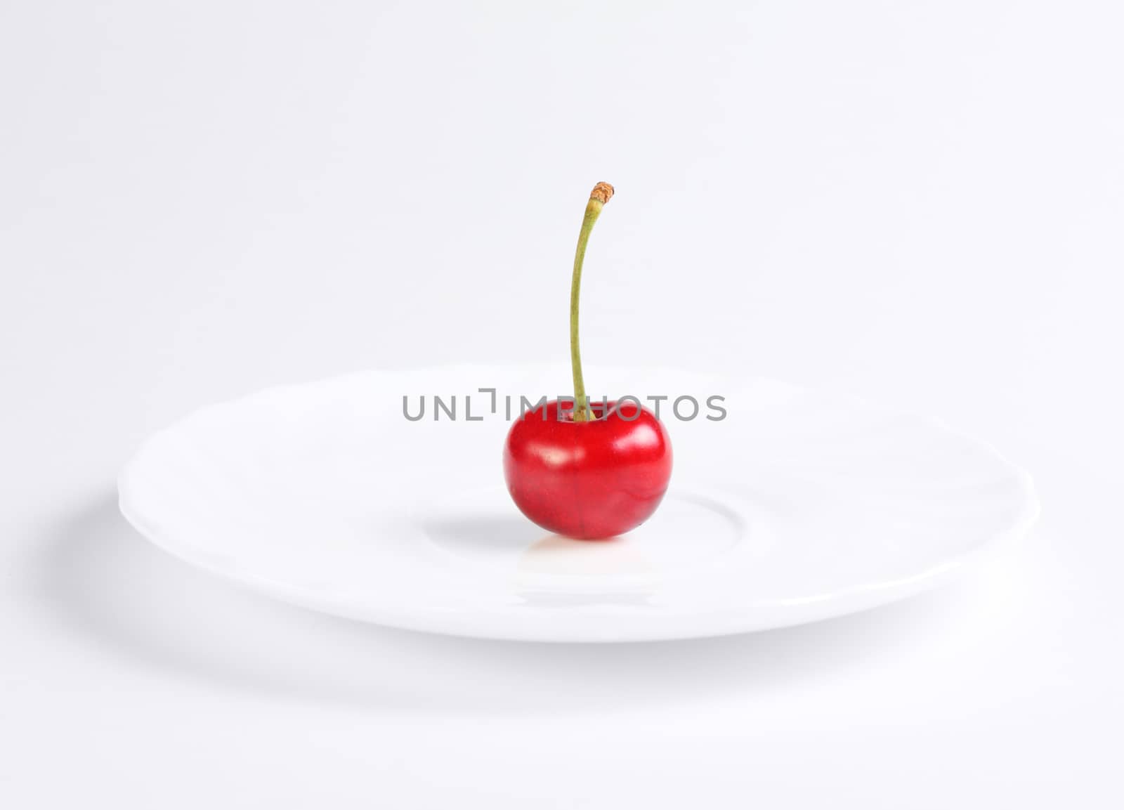 Fresh red cherry at the white dish