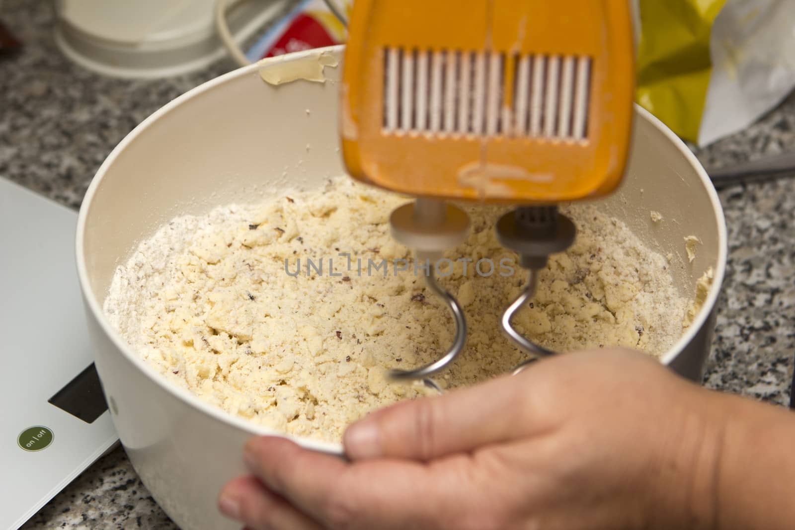 hand from a woman with a mixer baking christmas cookies