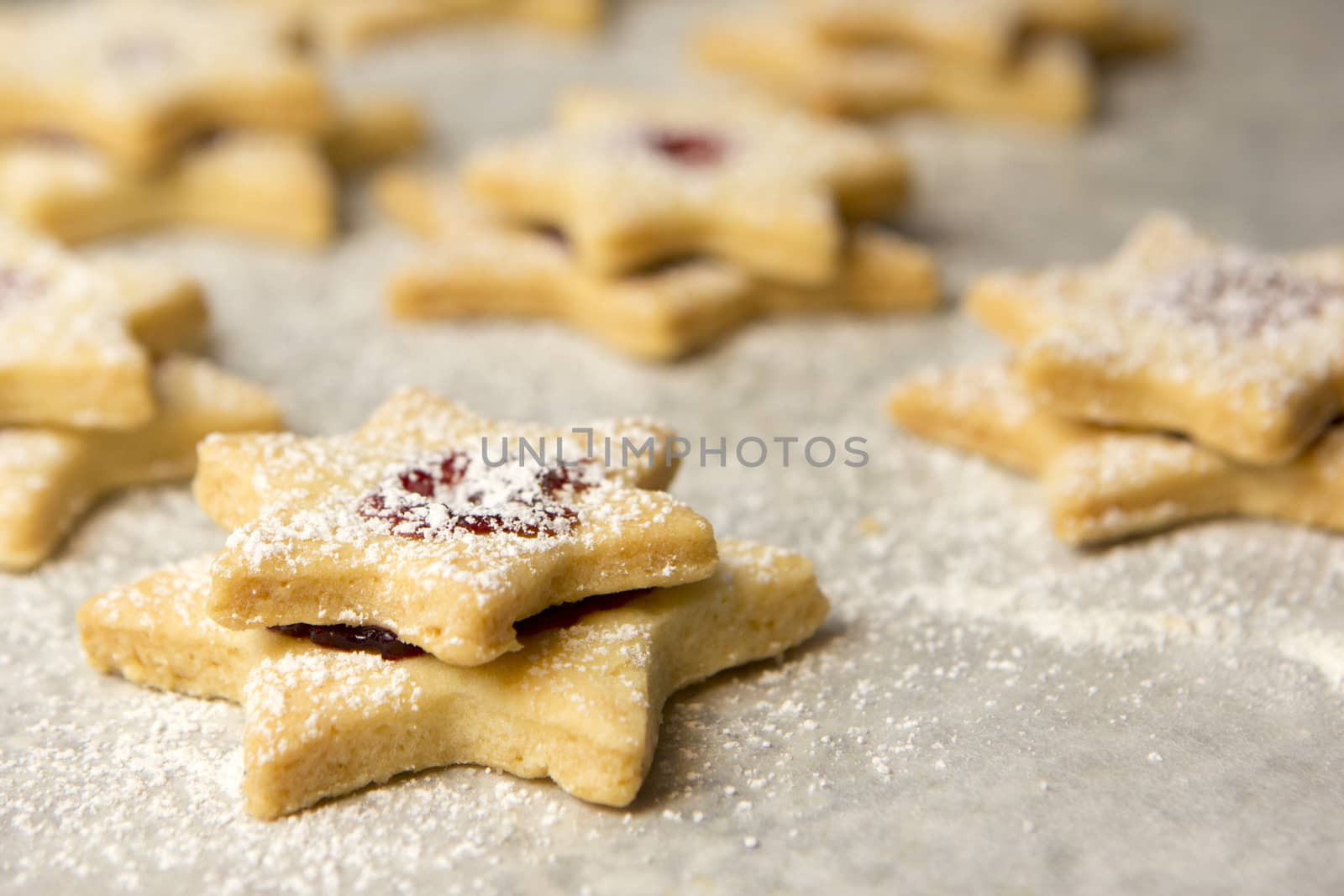 christmas cookies as stars with jam on baking paper