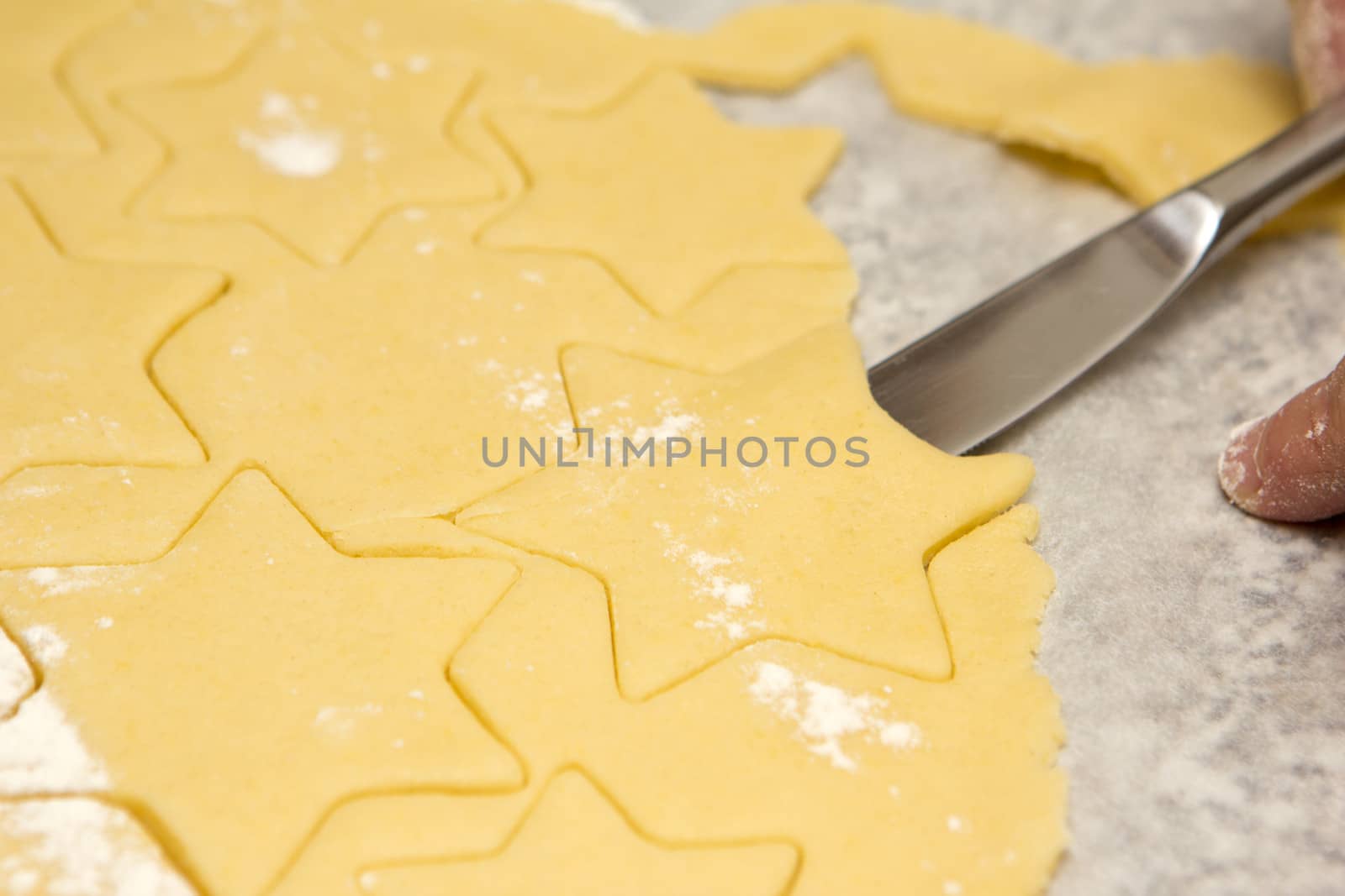 dough, cookie cutter with a knife on baking paper