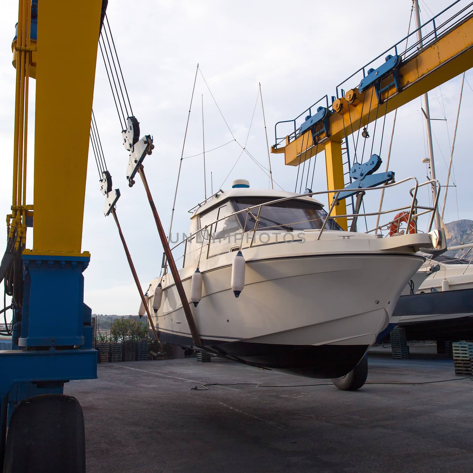 Boat wheel crane elevating motorboat to yearly paint task