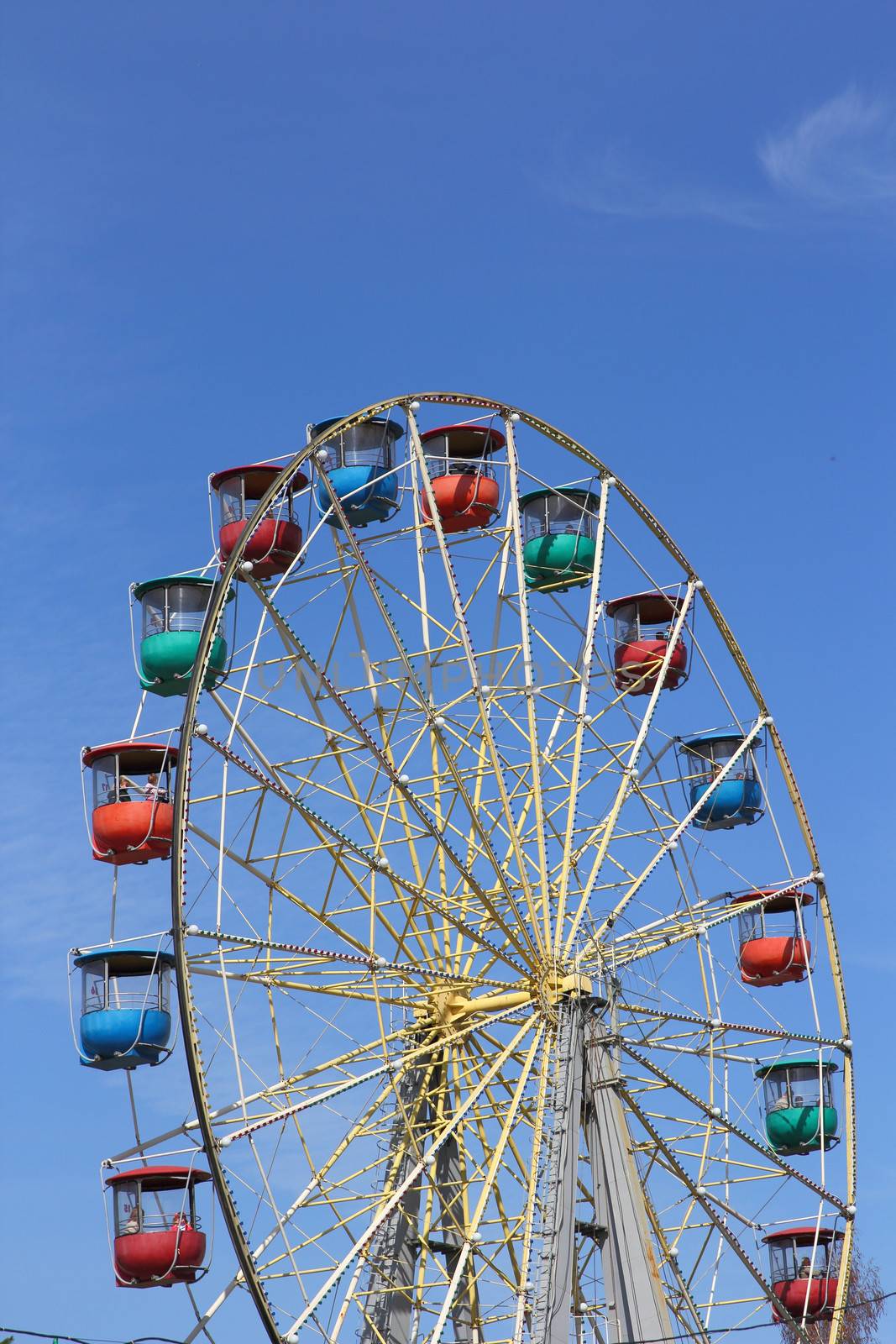 Atraktsion colorful ferris wheel against the blue sky by aarrows