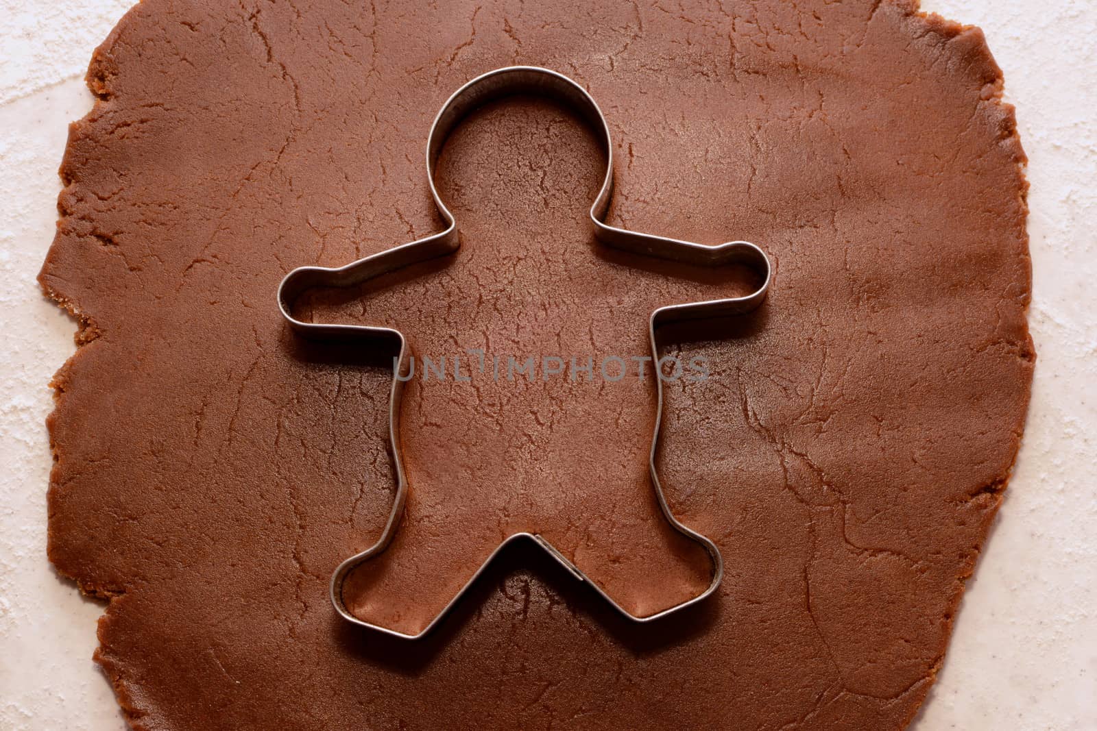 Cutting out a gingerbread man from cookie dough