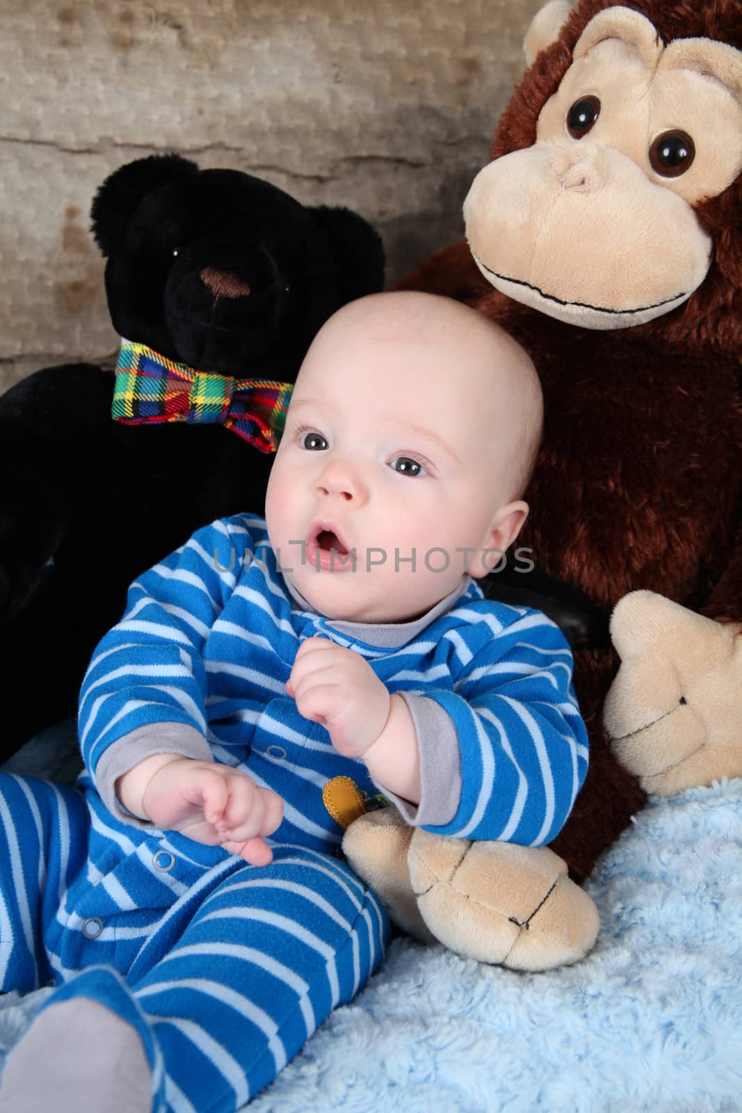 Cute baby boy sitting with his toy bears