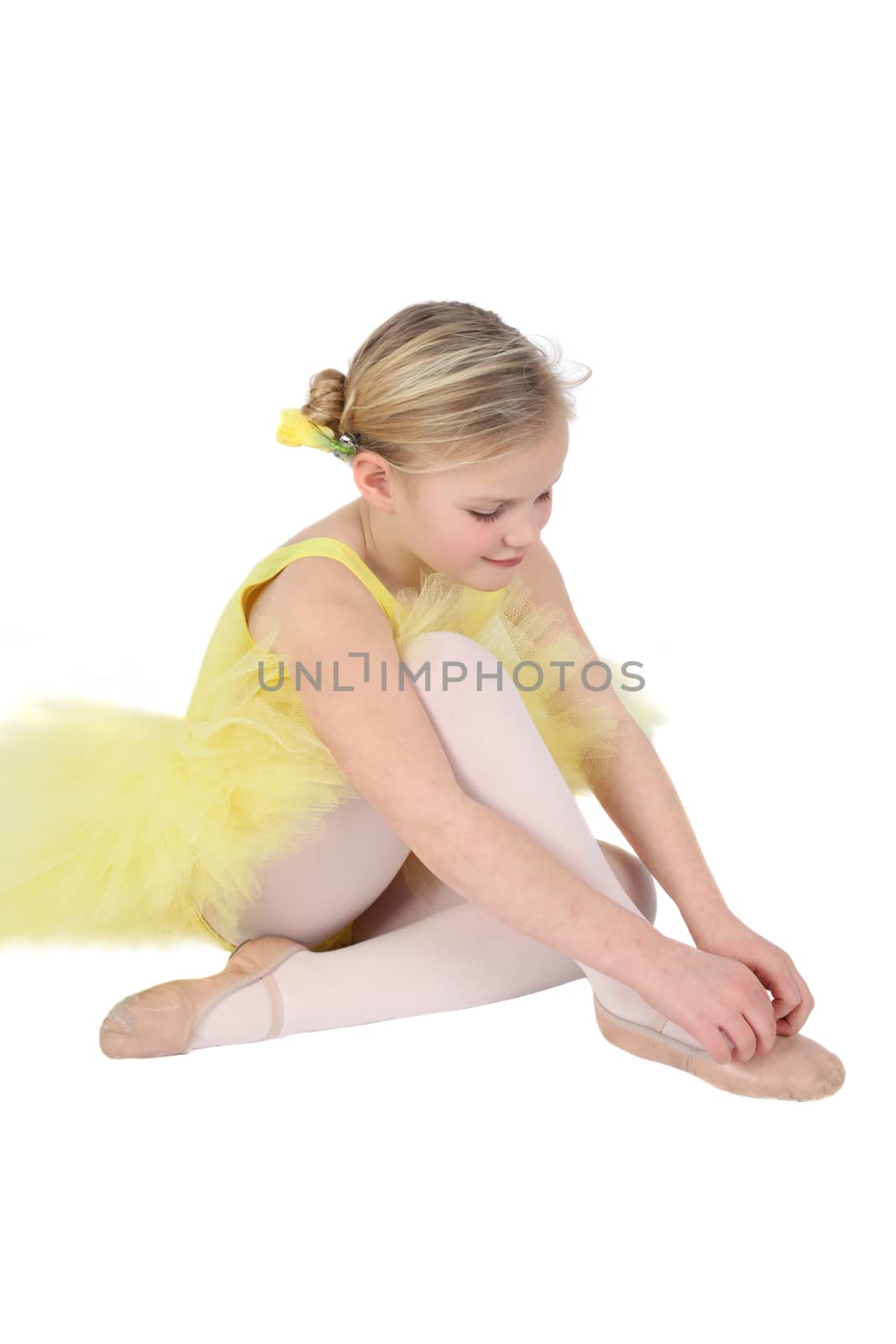Blond girl wearing a yellow ballet tutu on white background