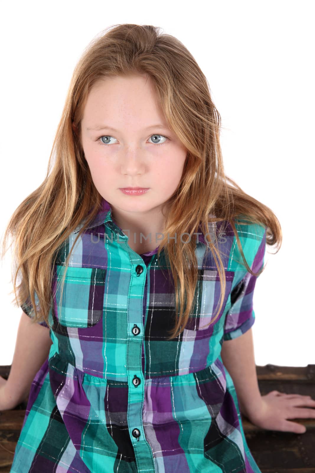 Young teenage girl sitting against white background
