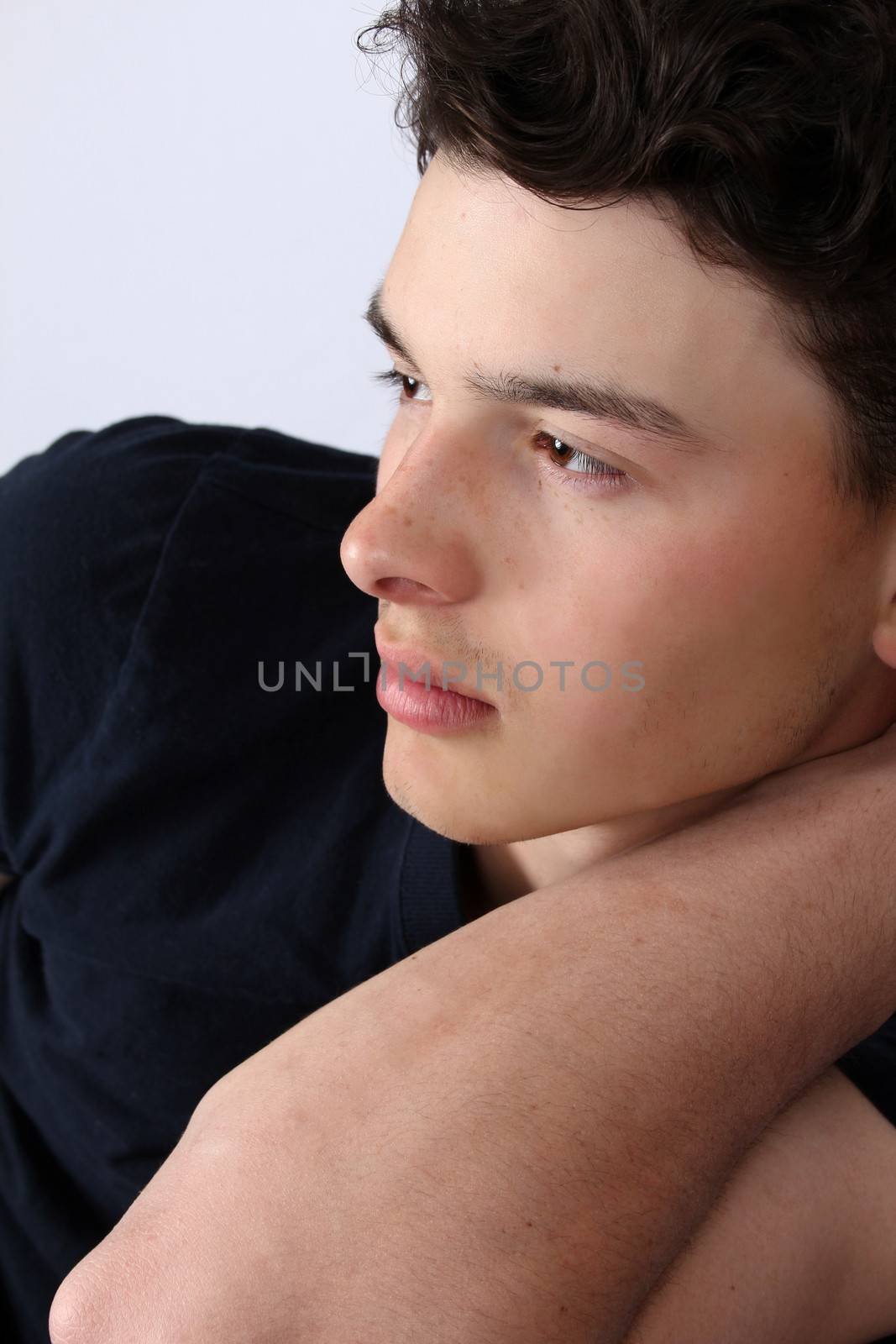 Attractive brunette male model on grey background wearing black
