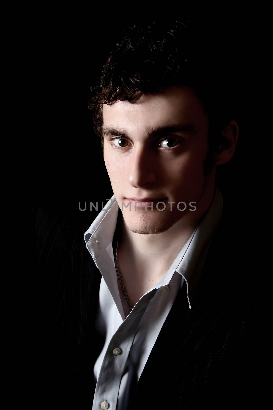 Attractive male model on a black background with uneven lighting effect