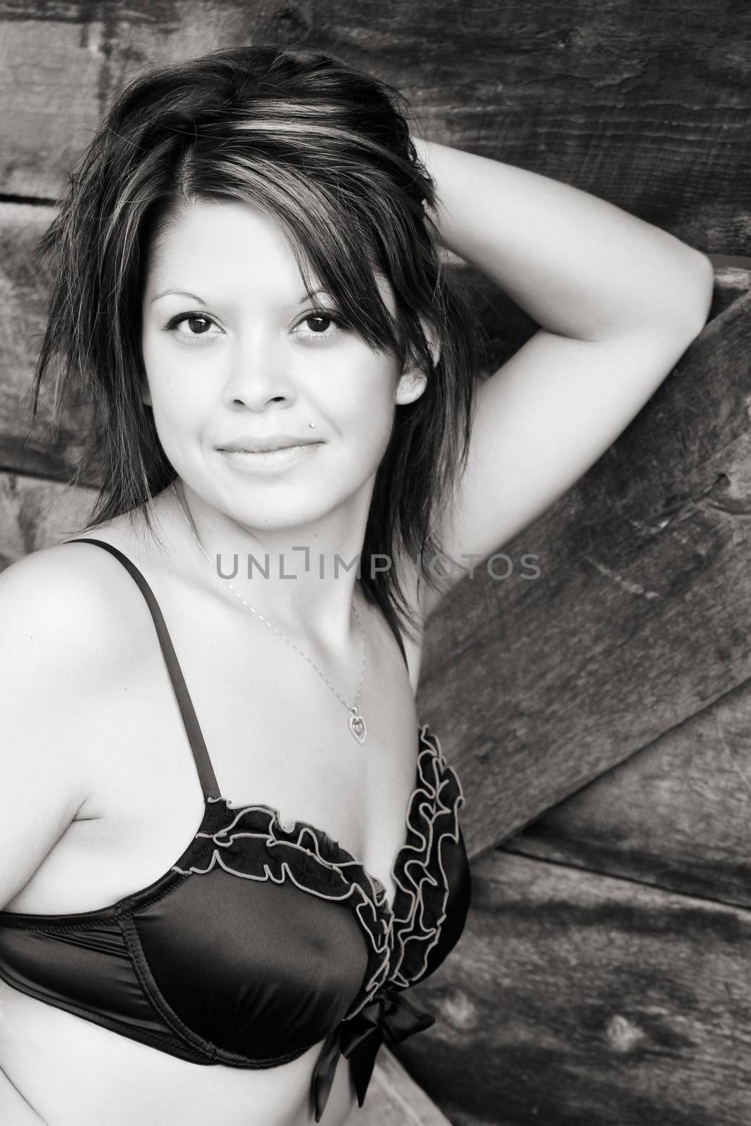 Beautiful brunette female in lingerie againt textured wood background