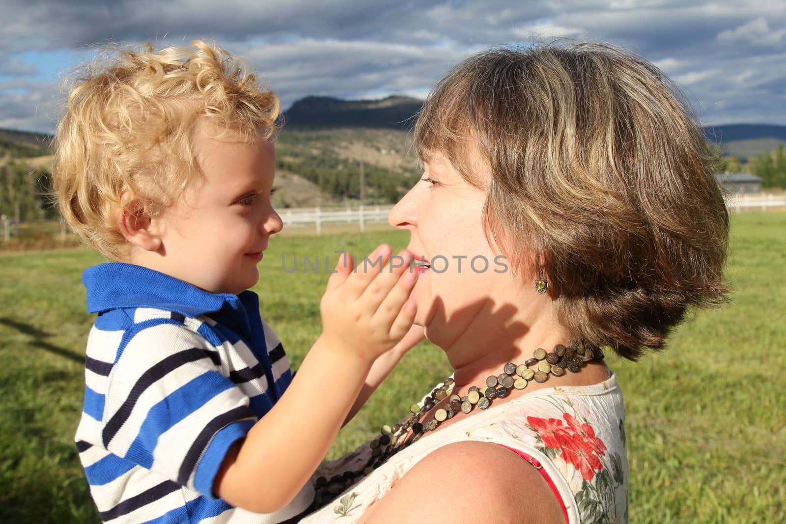 Grandmother and grandson playing outside in the field 