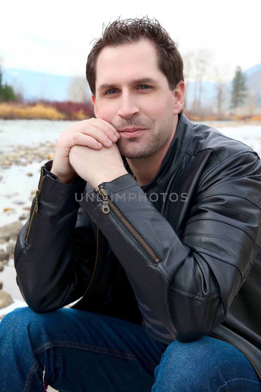 Attractive male outdoors wearing a black leather jacket