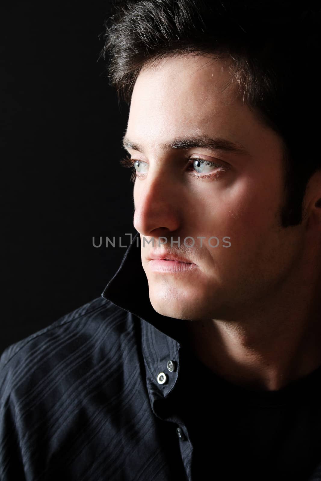 Attractive brunette male model against black background