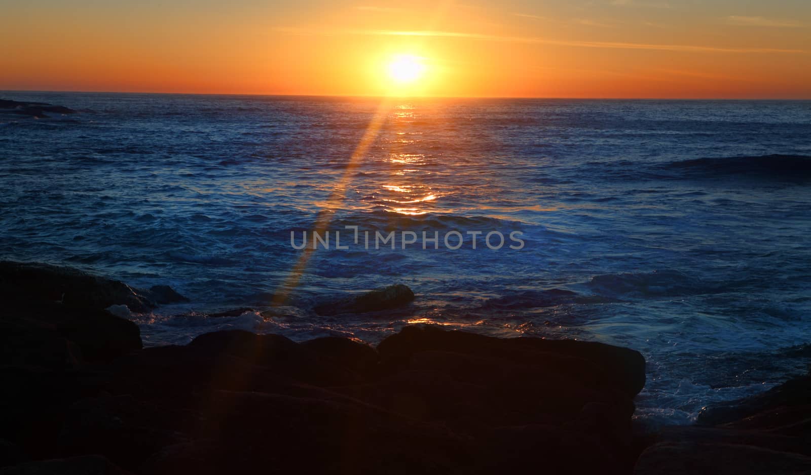 The sun pops up on the oceans horizon sending golden orange rays onto the earth   Mackenzies Bay.  Single shot, no filter