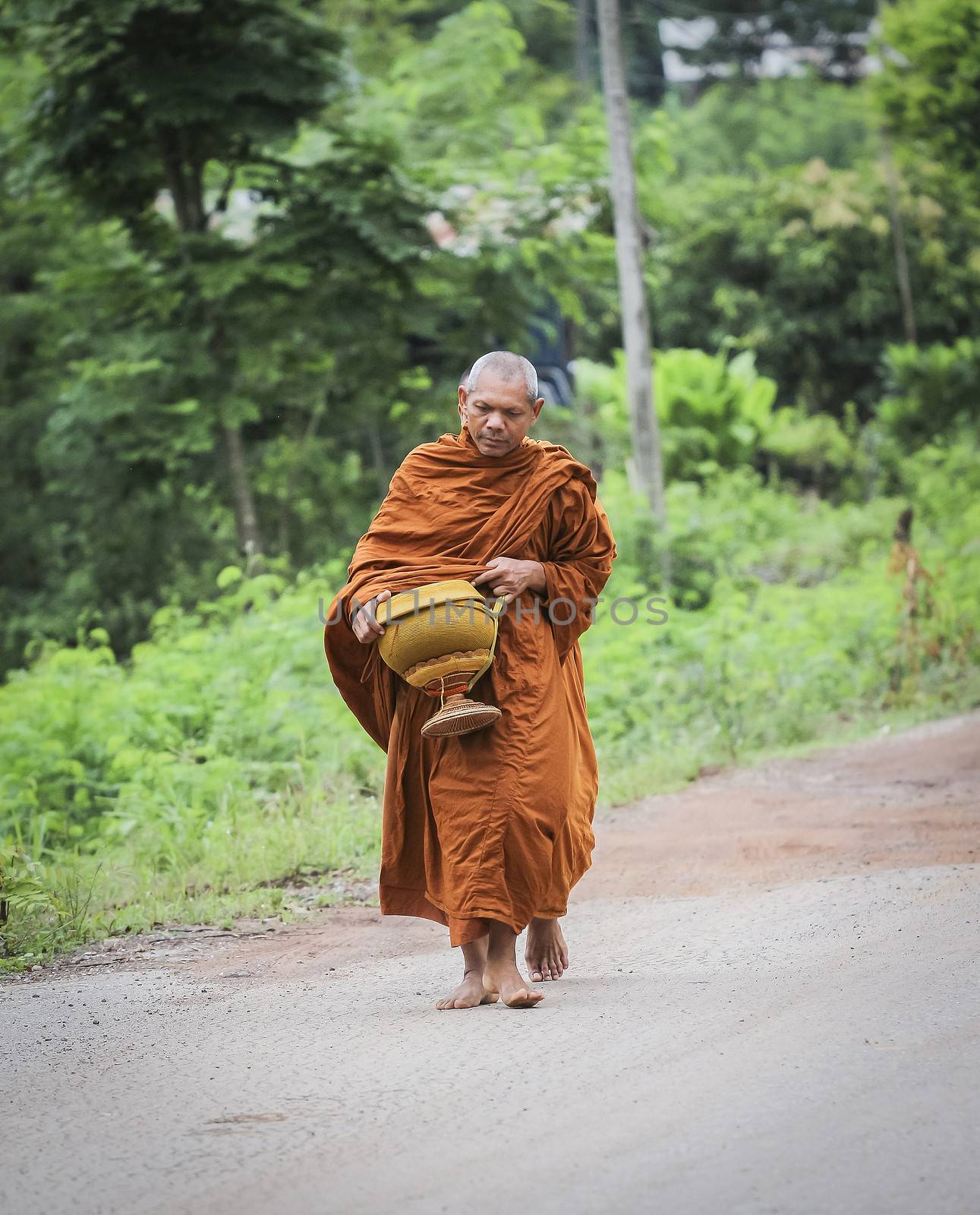 Every day very early in the morning, the monks walk the streets to beg give food offerings to a Buddhist monk 