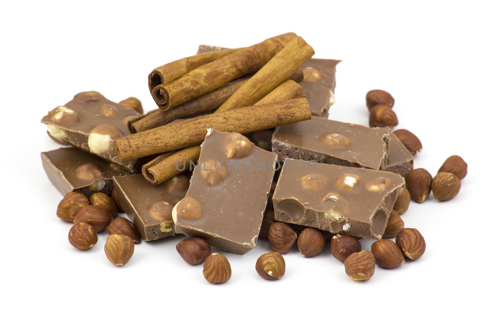 chocolate, cinnamon and nuts on white background
