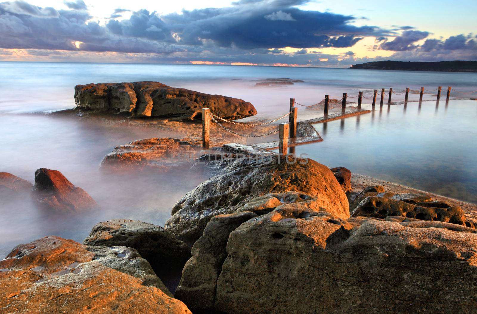 Pre sunrise shot of the coastline of Maroubra and Mahon Pool.  There is a light that illuminates the pool at night which is interplaying with the natural light.   Long exposure bracketed with lens filter