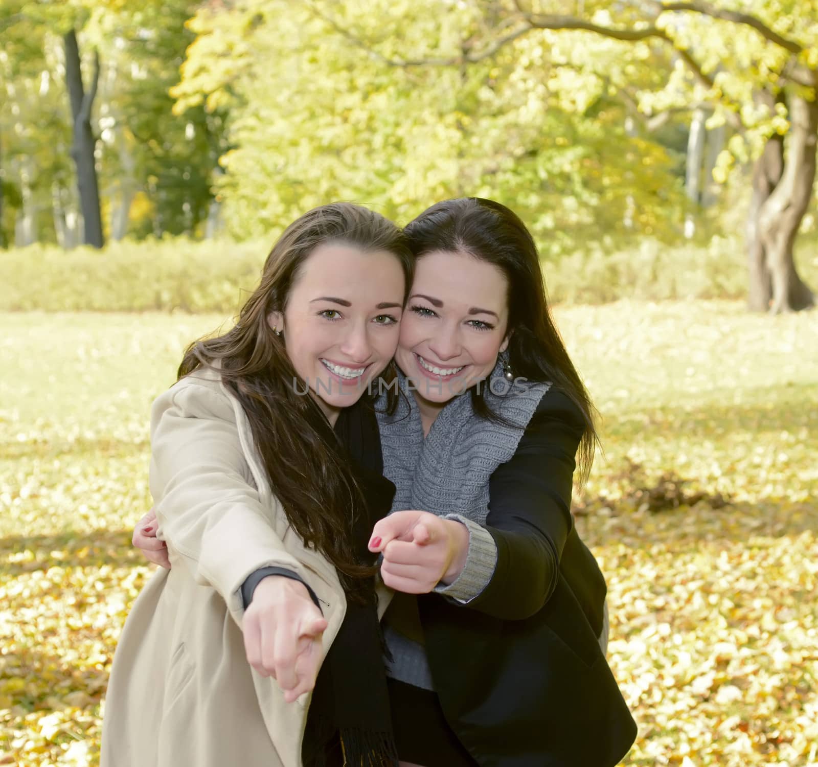 happy sisters pointing with forefinger