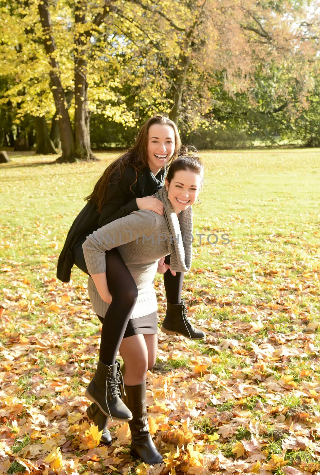 two happy girlfriends in autumn park