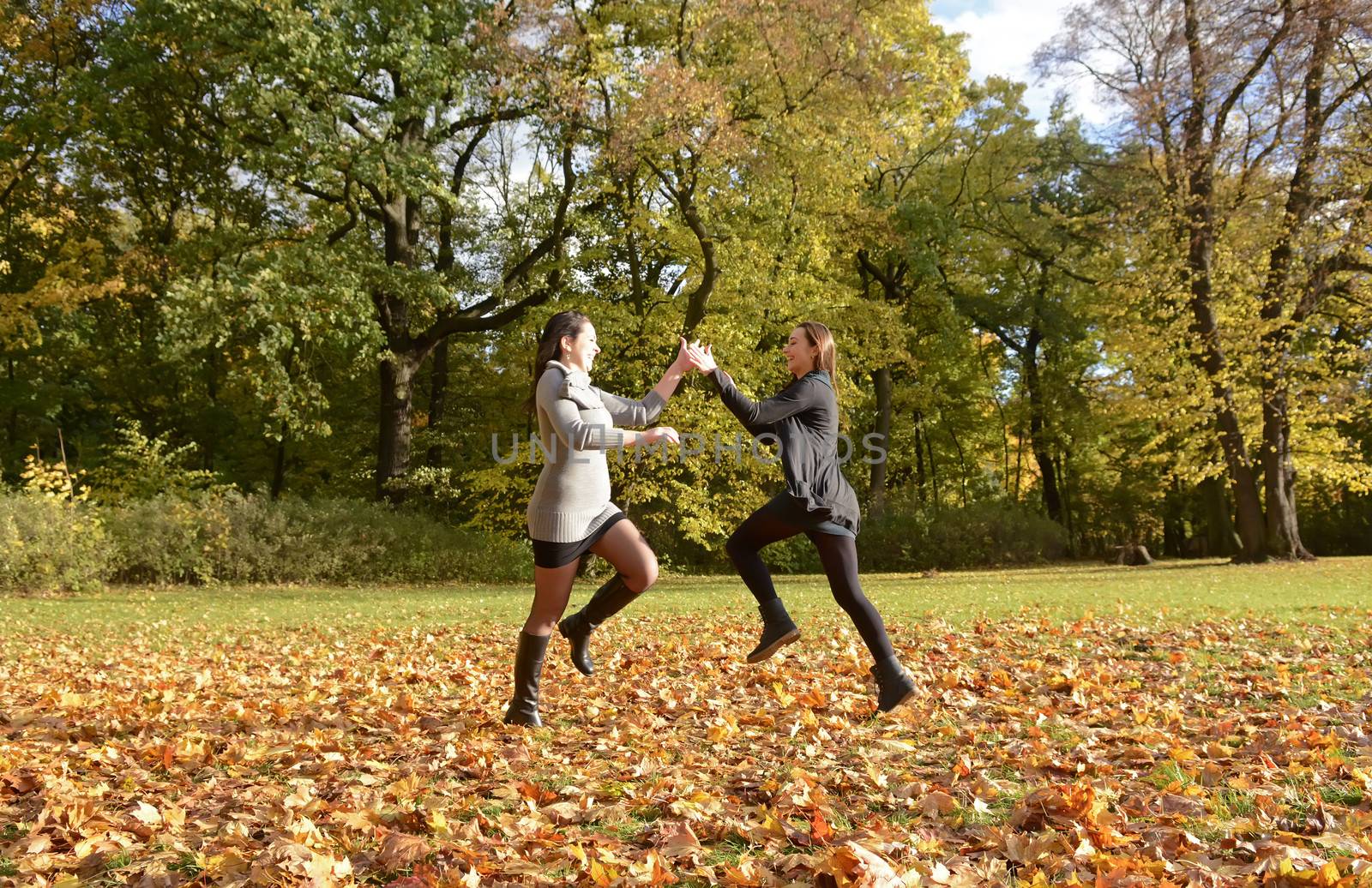 pretty young women dancing in autumn park