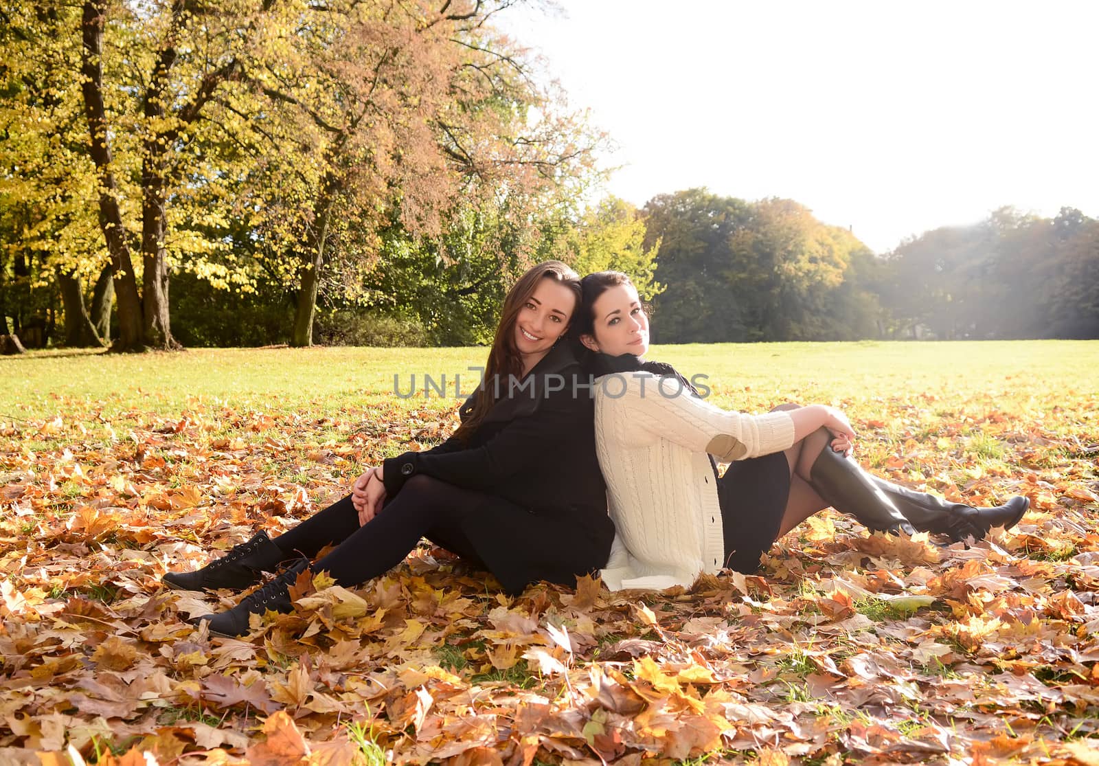 girlfiends sitting in autumn park