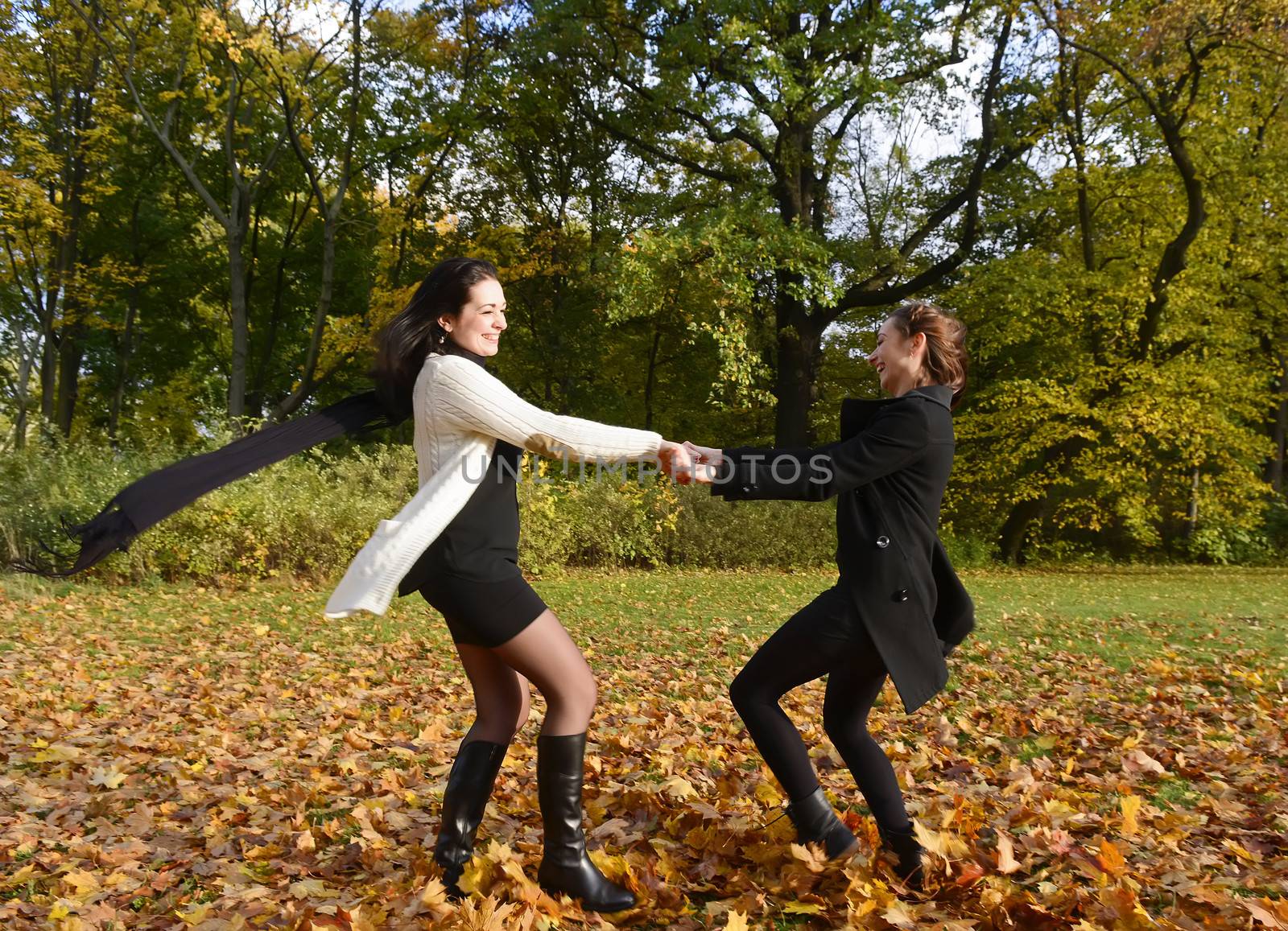 happy young women dancing in autumn park