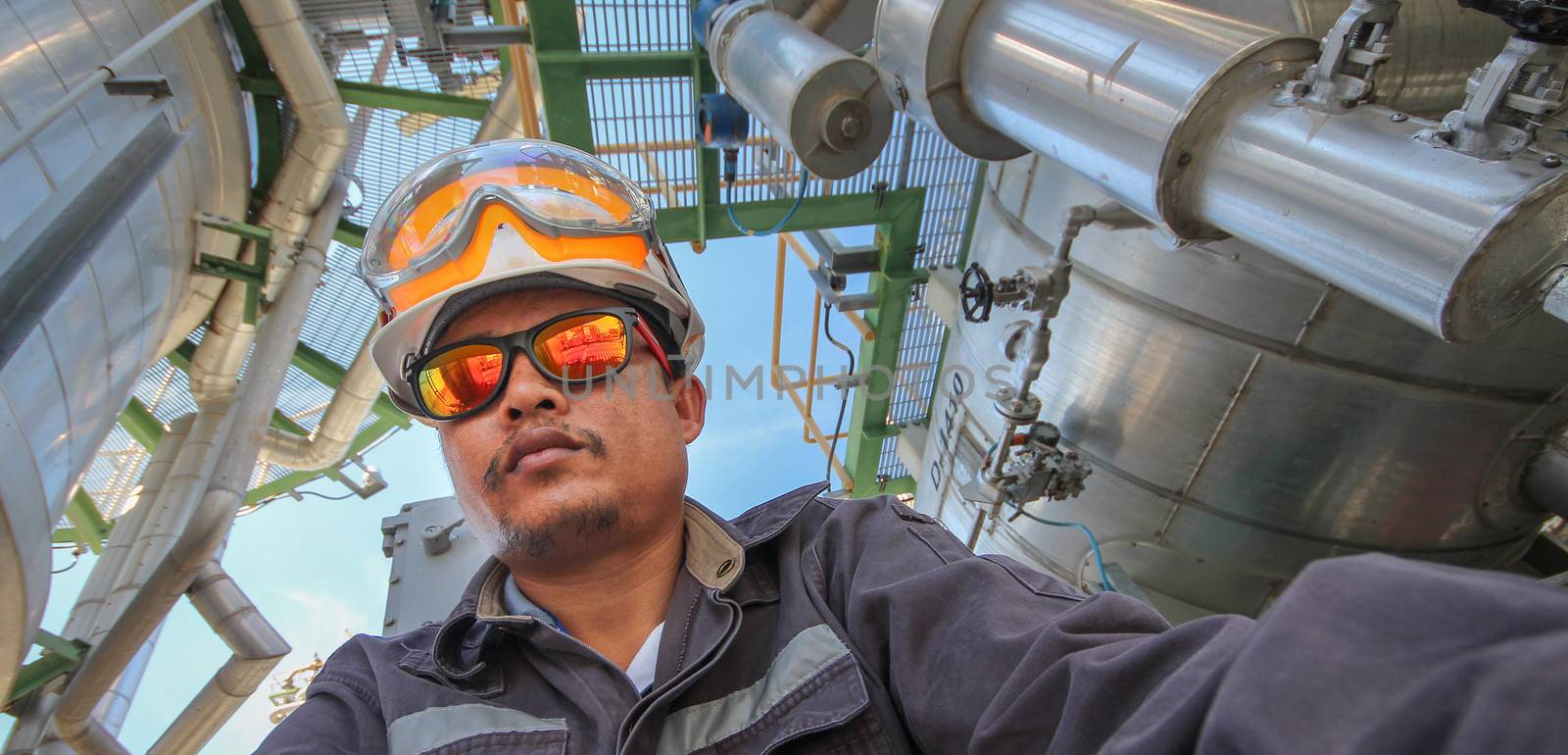 A man with personal protection suit in refinery plant