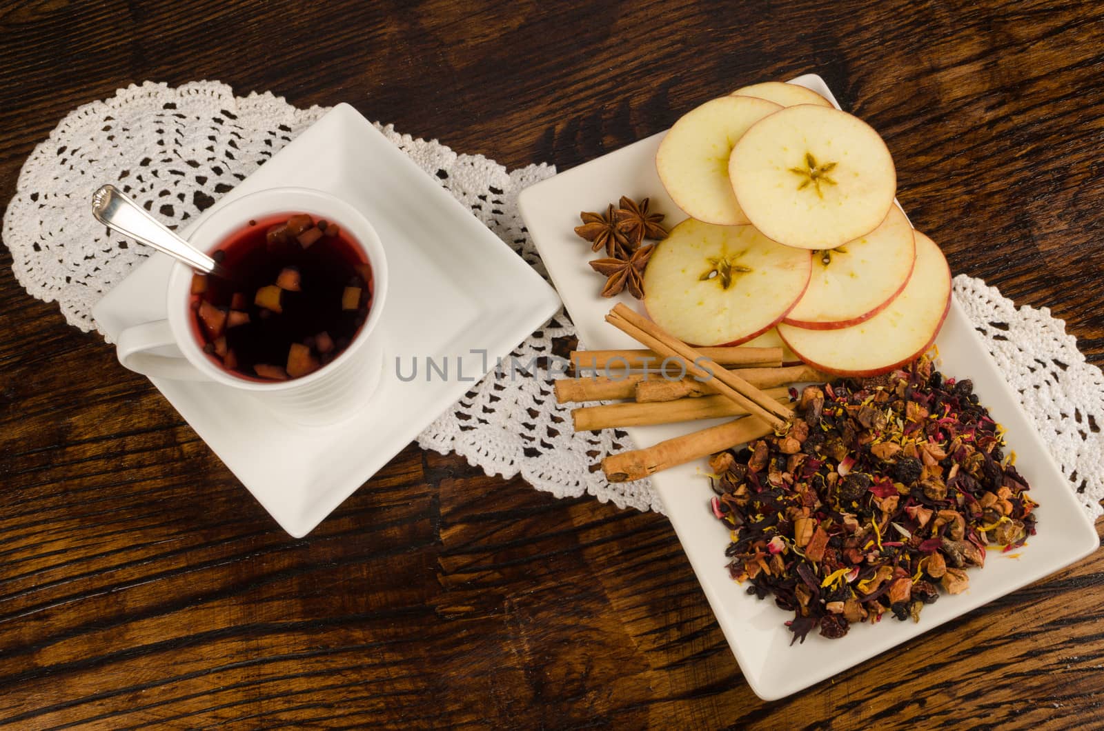 Cup of hot fruit tea next to its ingredients