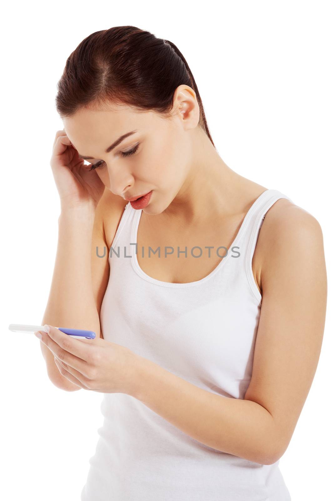 Sad, worried woman with pregnancy test. Isolated on white.