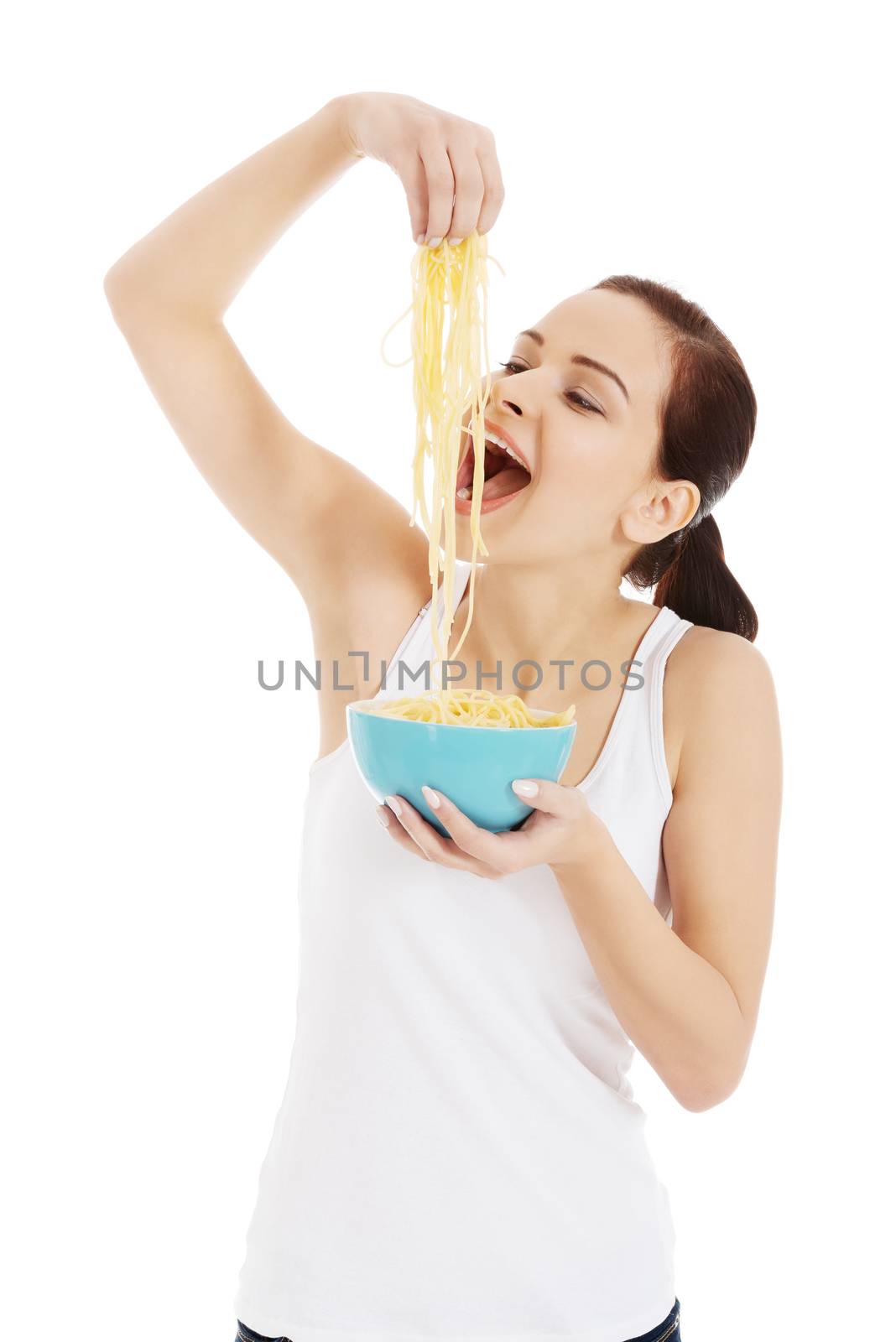 Beautiful woman eating pasta from a bowl. Isolated on white.