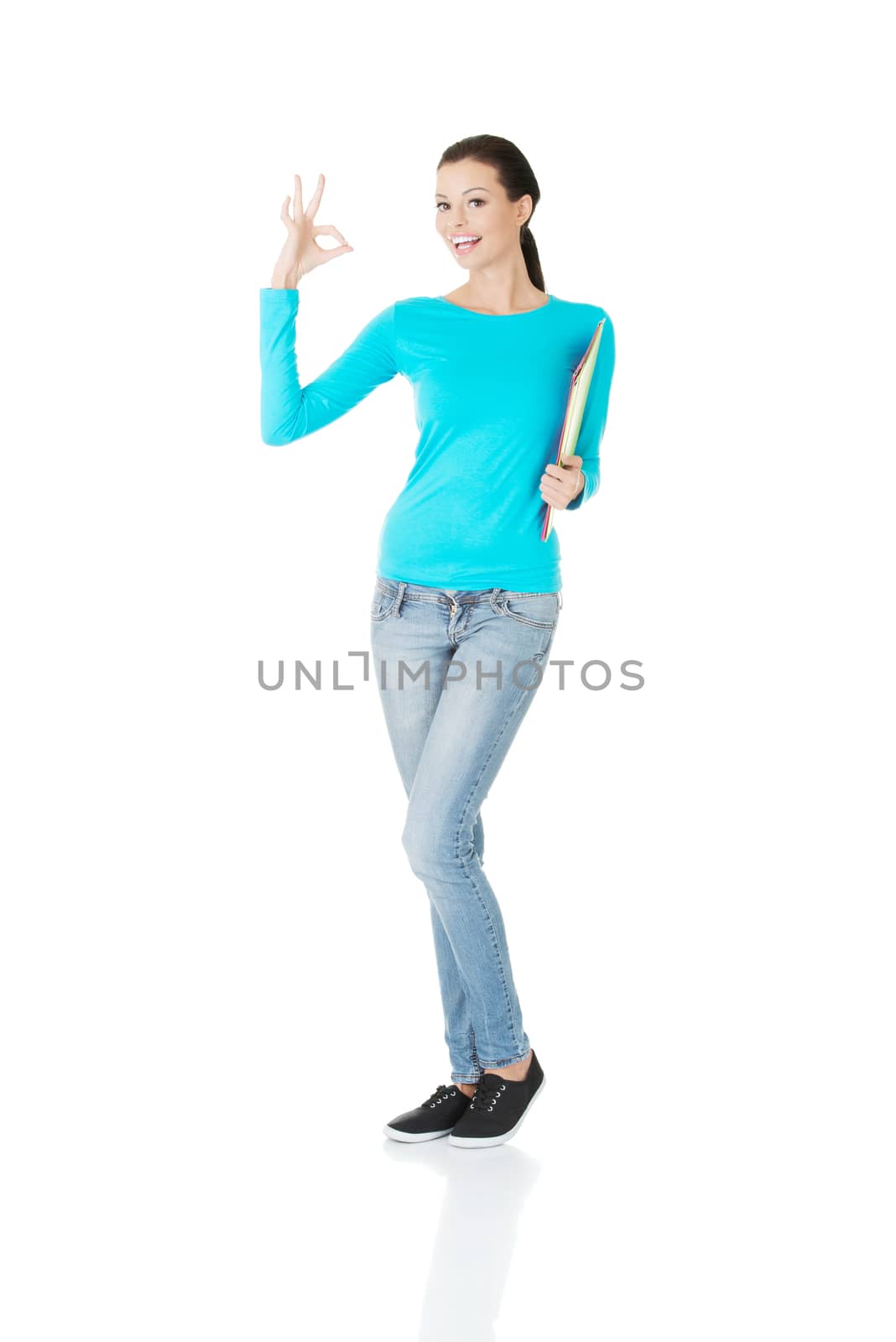 beautiful casual woman holding files and showing OK. Isolated on white.