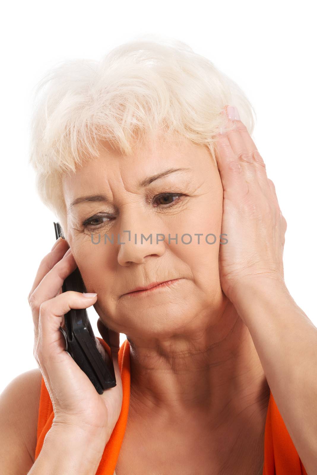 An old lady talking through phone.She is receiving bad news. Isolated on white.