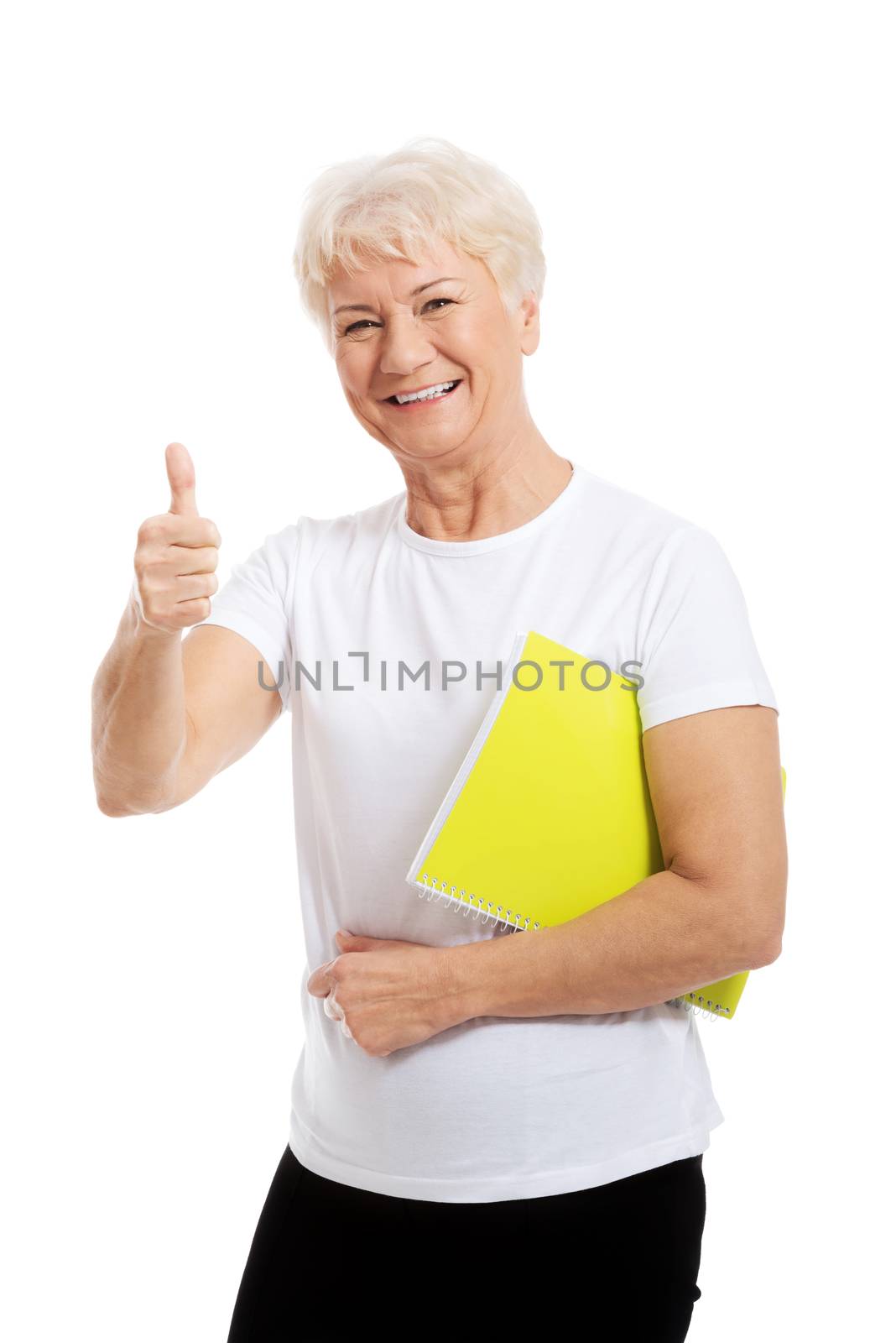 An old woman holding workbook and showing OK. Isolated on white.