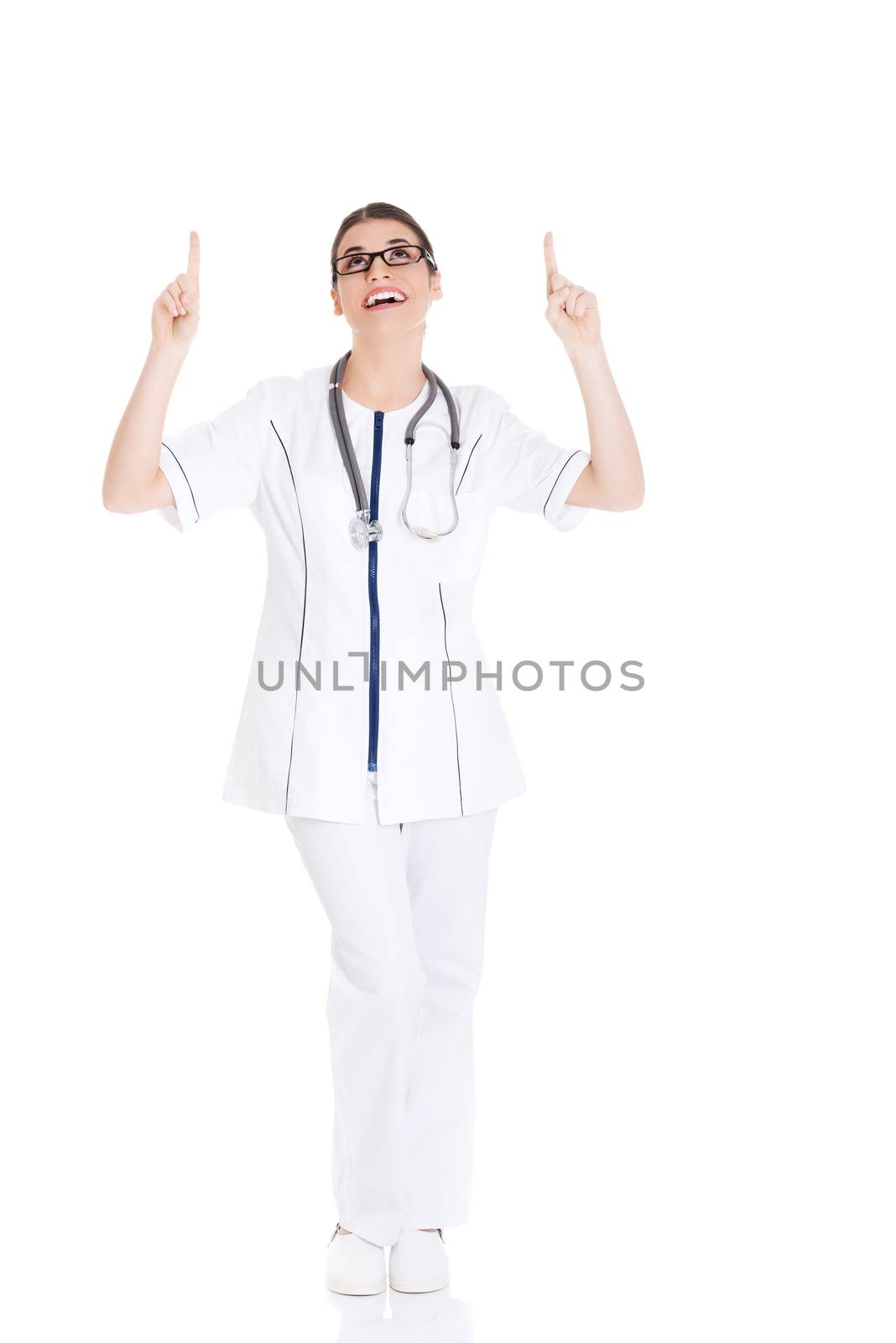 Beautiful young woman doctor pointing up. by BDS