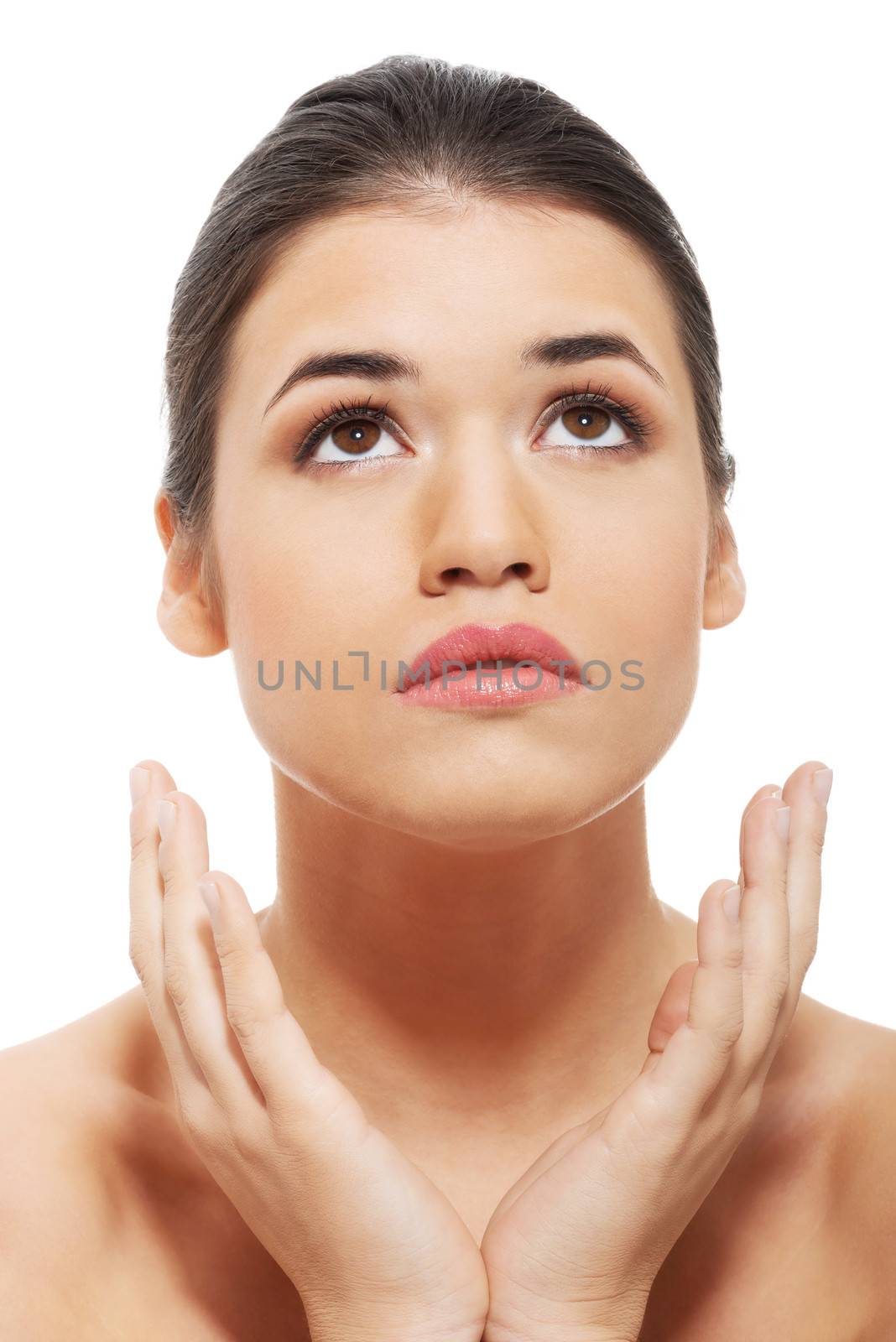 Portrait of beautiful woman with her hands under face and looking up. Isolated on white.