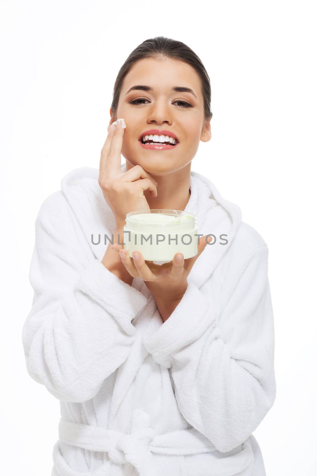 Beautiful woman in bathrobe with face cream. by BDS