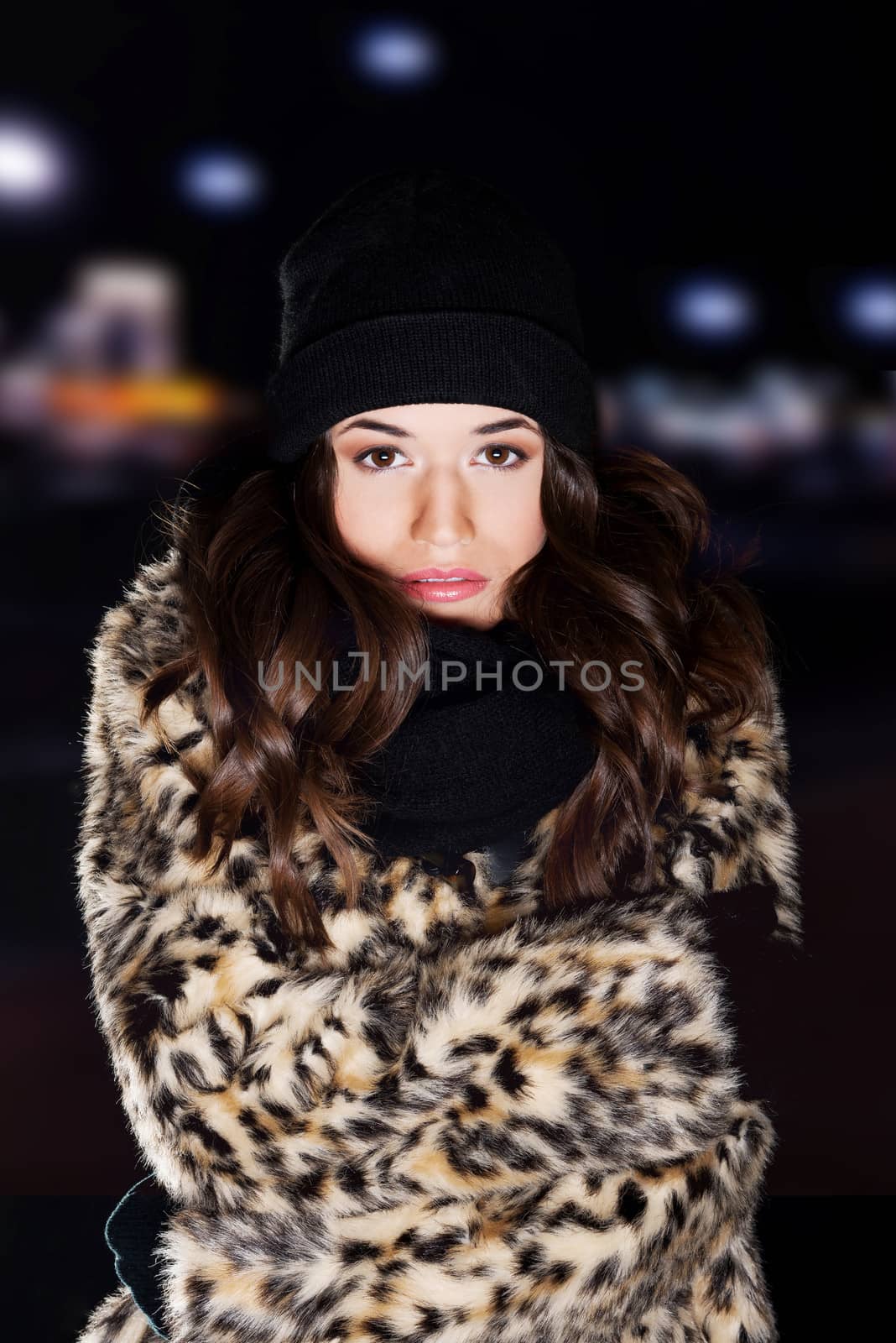 Young woman wearing fur at cold night.