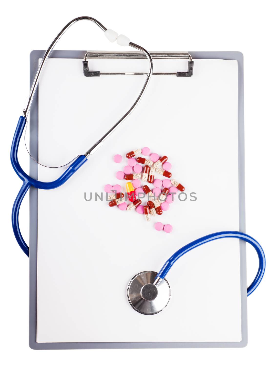 Blank sheet on clipboard with pills and stethoscope over white background