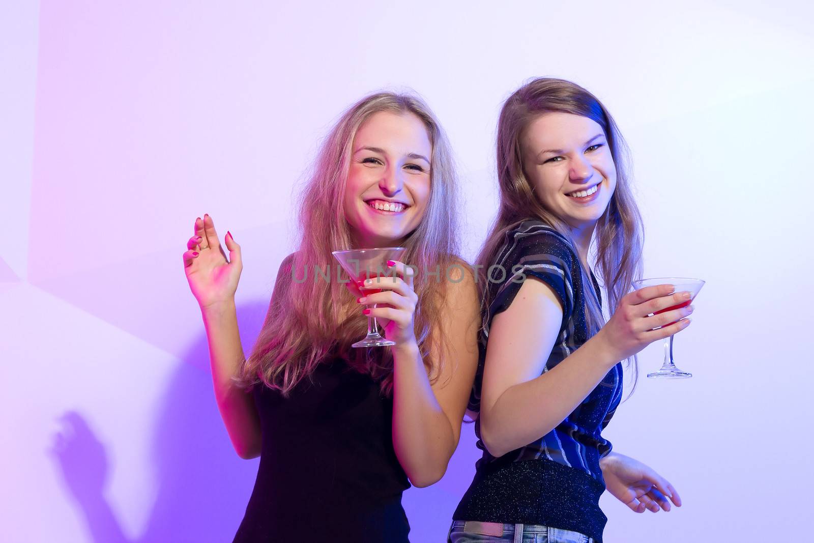 Group stylish women standing in a row toasting with flutes of champagne