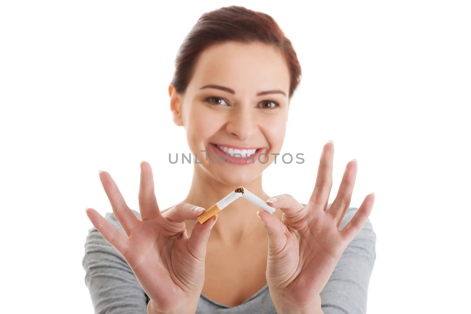 Young beautiful woman holding broken cigarette in front. Isolated on white.