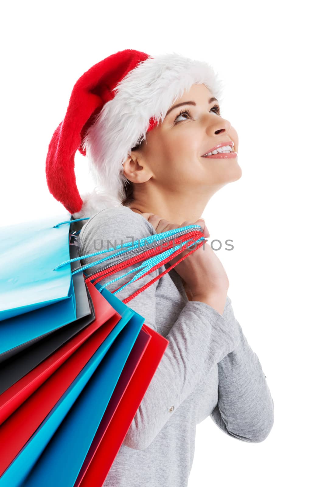 Beautiful woman in santa hat carrying shopping bags. by BDS