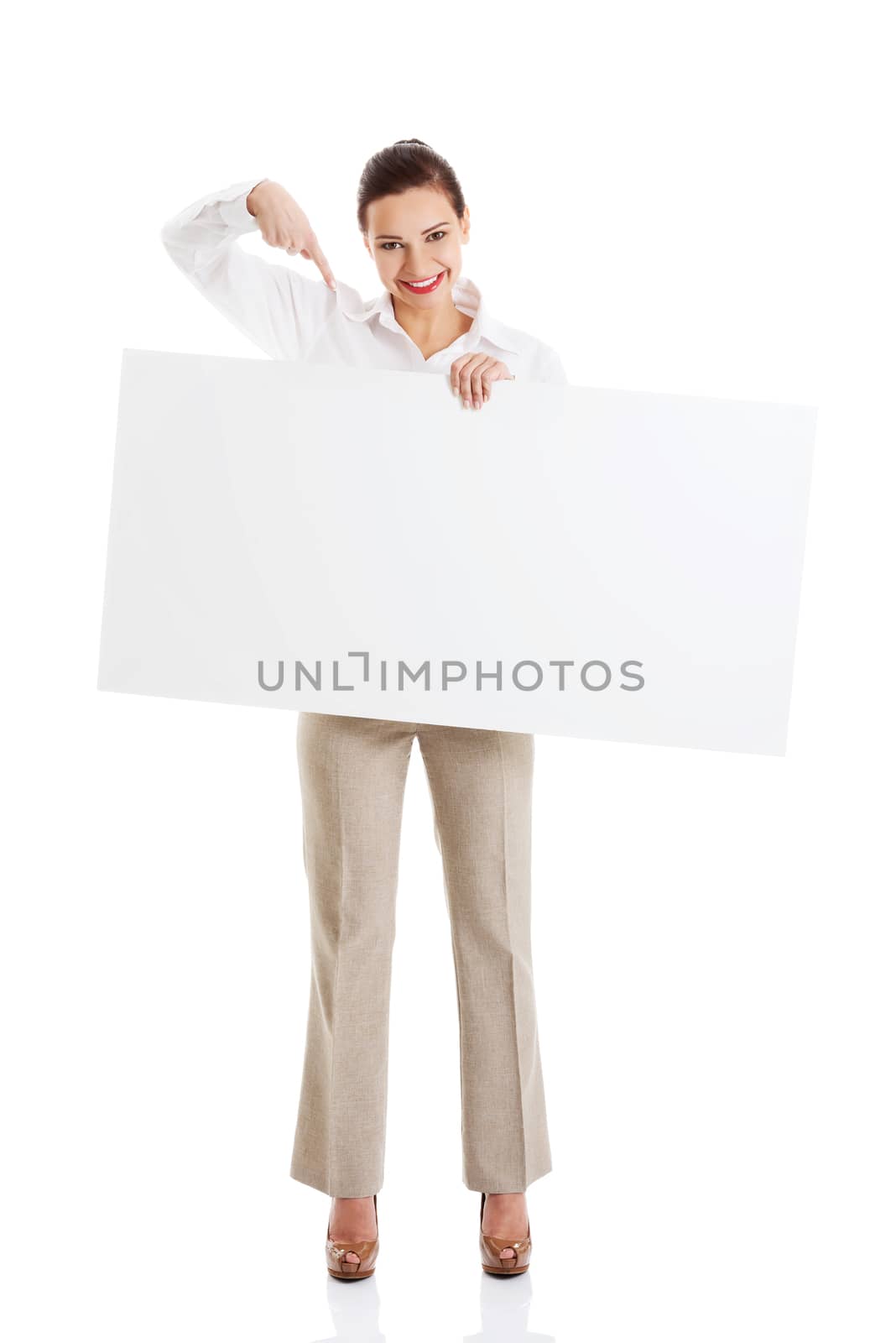 Beautiful business woman pointing on copy space. Isolated on white.