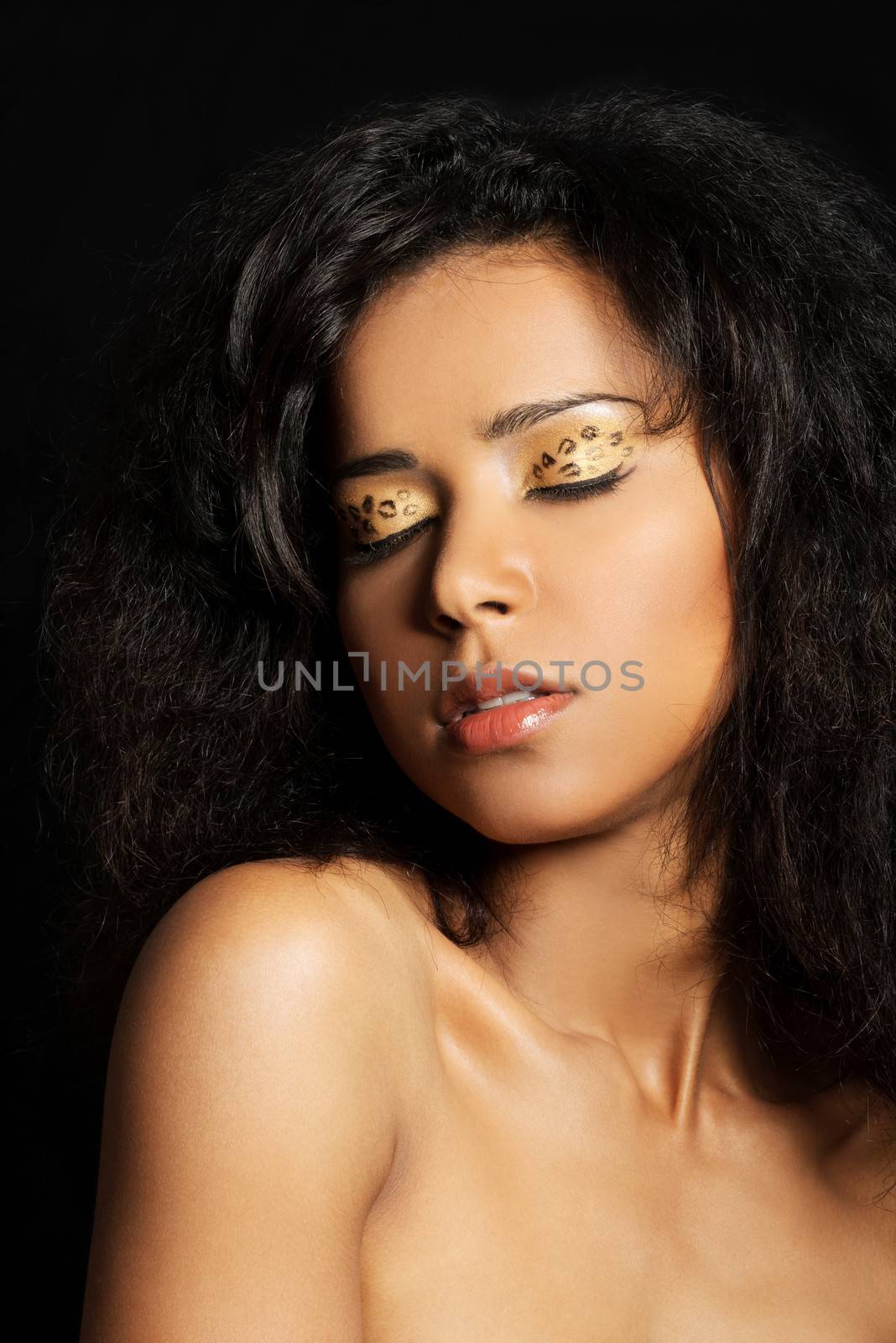 Beautiful mulatto woman with tiger make up. Over black background.