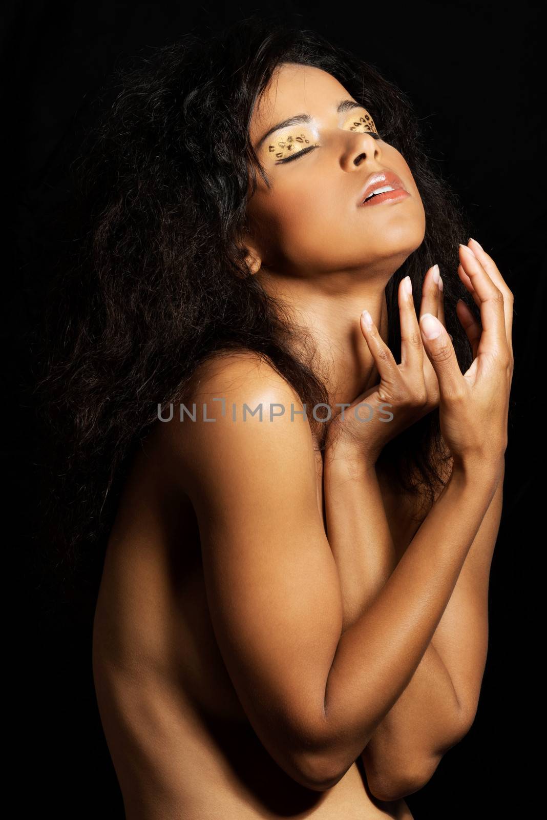 Beautiful mulatto woman with tiger make up. Over black background.