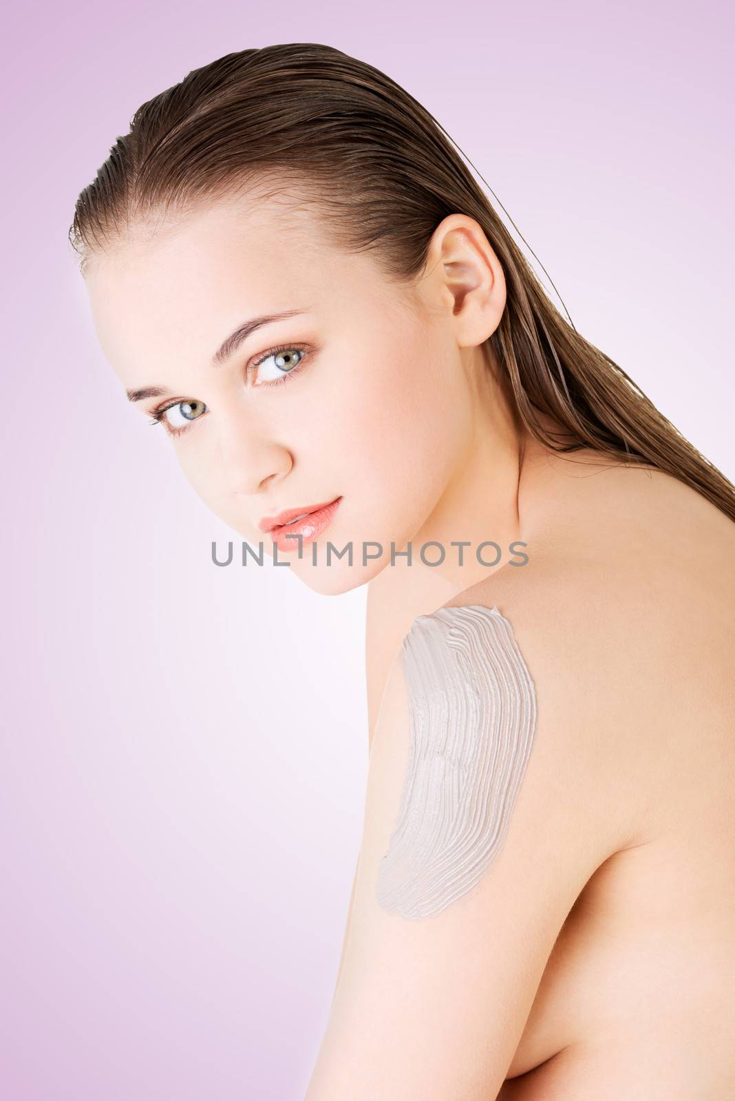 Beautiful face of spa woman with healthy clean skin and clay mask on arm.