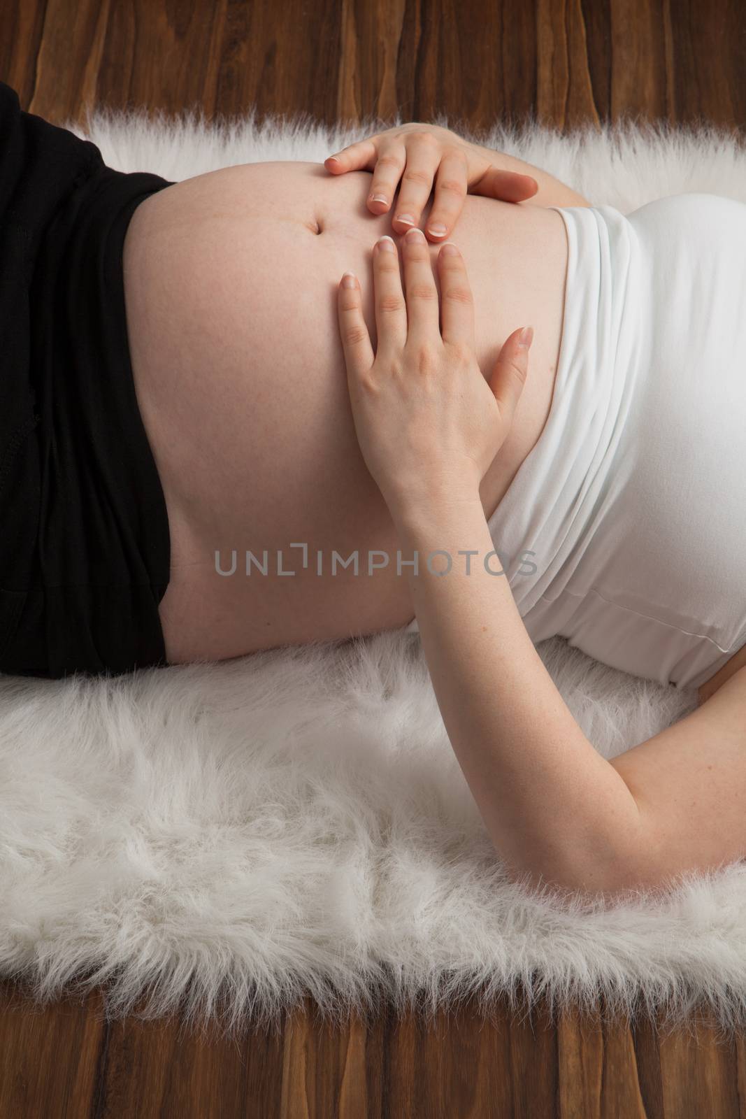 Pregnant woman with hands over her stomach  by Izaphoto