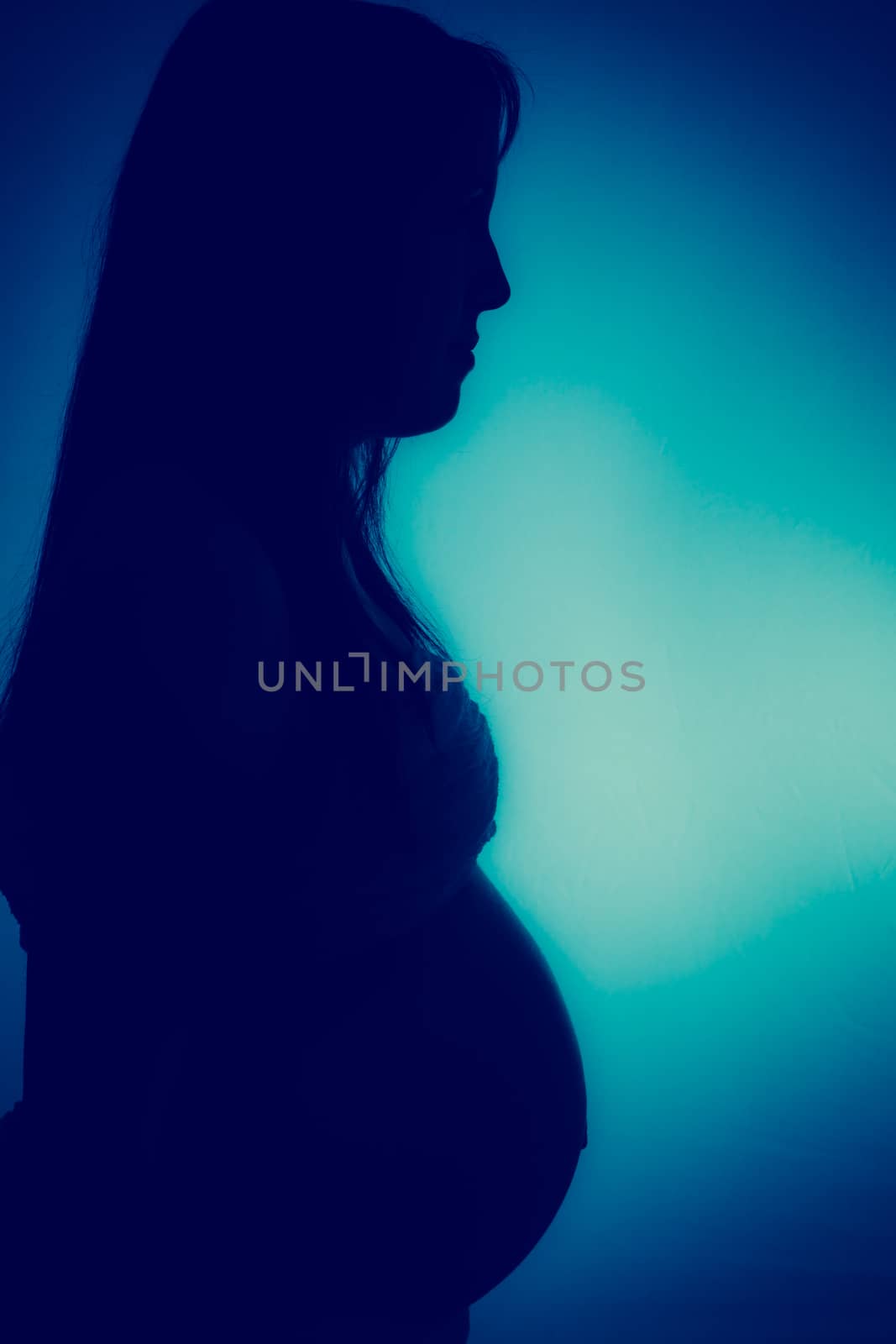 Pregnant woman in shadow with blue effect