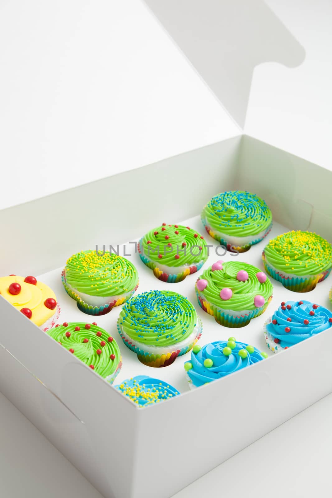 Colorful decorated cupcakes in a white box